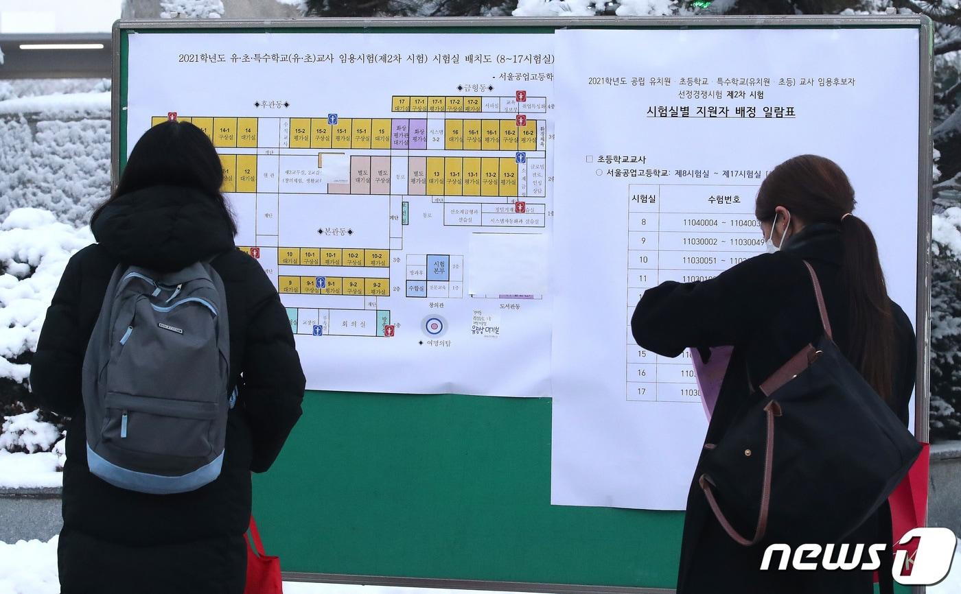본문 이미지 - 서울특별시 공립 유치원·초등학교·특수학교(유치원 ·초등) 교사 임용후보자 선정경쟁 제2차 시험에서 응시생들이 배치표를 확인하고 있다. 2021.1.13 ⓒ 뉴스1 임세영 기자