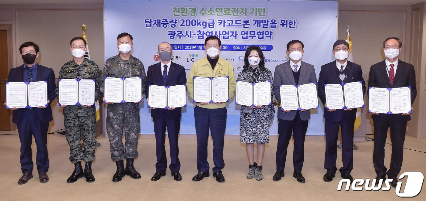 본문 이미지 - 이용섭 광주시장이 14일 오후 광주시청 비즈니스룸에서 친환경 수소연료전지 기반 탑재중량 200kg급 카고드론 개발을 위한 업무협약을 체결한 후 기념촬영을 하고 있다. 왼쪽부터 이해창 한국항공우주연구원소장, 김환필 제11공수특전여단장, 최순건 제31보병사단장, 김지찬 LIG넥스원 대표이사, 이용섭 광주광역시장, 안혜리 태경전자 대표이사, 정연석 한국항공기술KAT 대표이사, 김명준 한국전자통신연구원장, 김광엽 하이즈항공 대표이사.(광주시 제공)2021.1.14/뉴스1 ⓒ News1