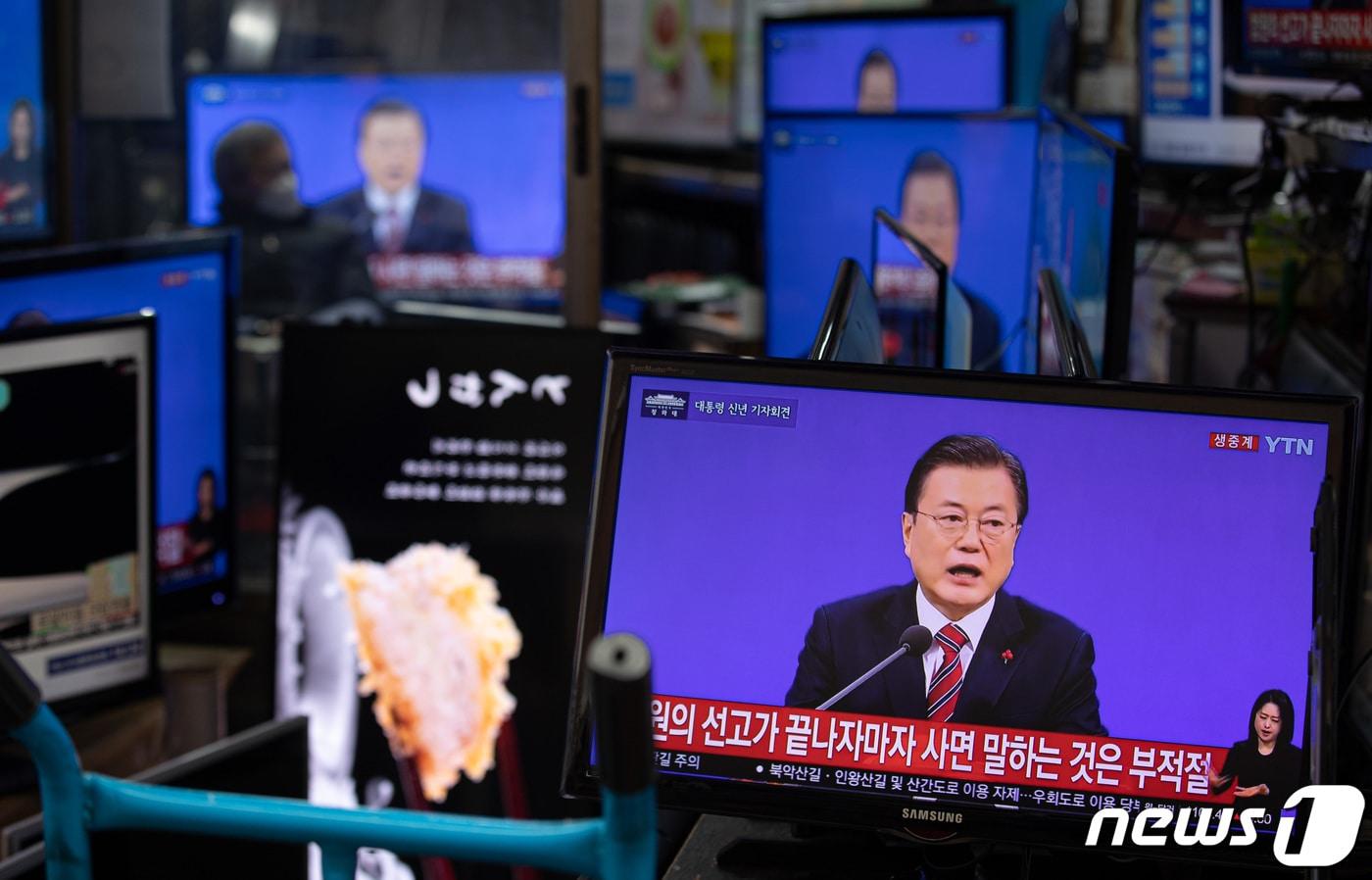 본문 이미지 - 18일 서울 황학동 시장에서 한 상인이 문재인 대통령의 신축년(辛丑年) 기자회견을 TV를 통해 지켜보고 있다. 2021.1.18/뉴스1 ⓒ News1 이재명 기자