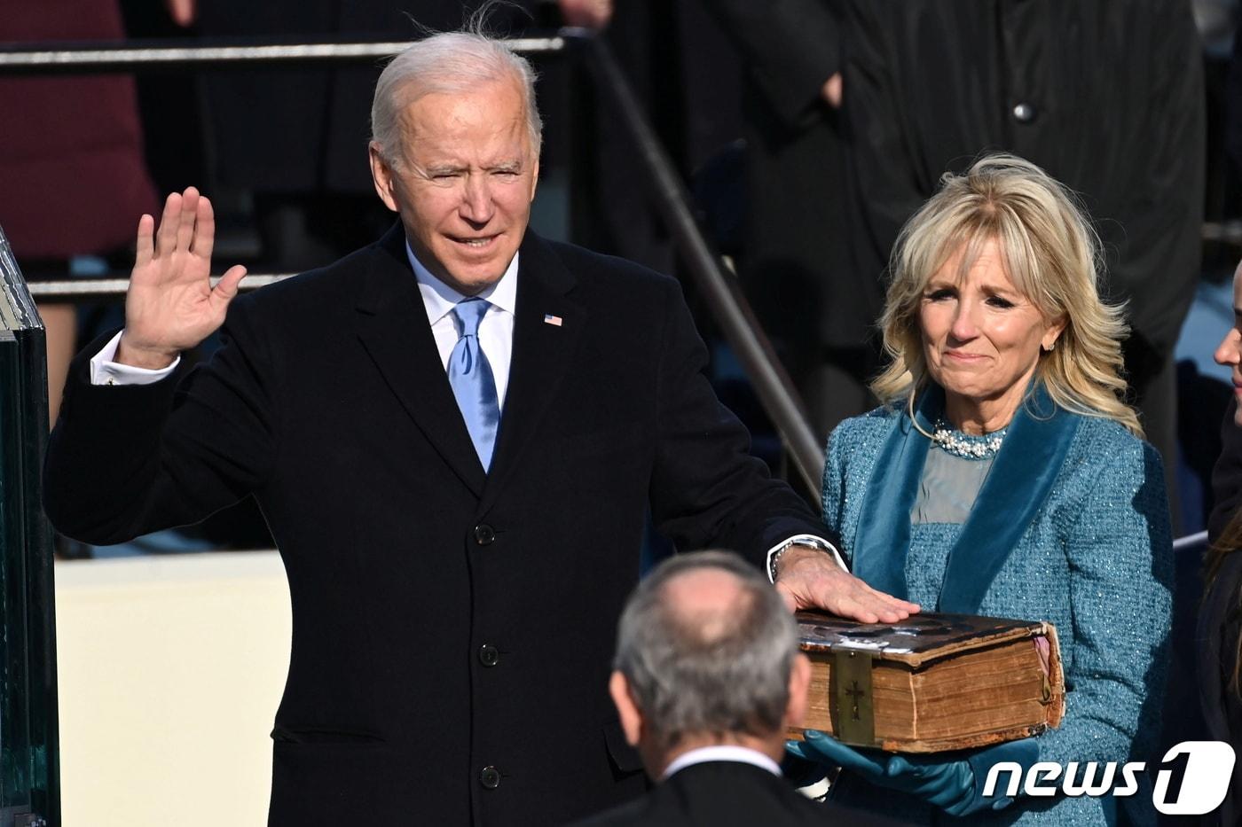 조 바이든 미국 대통령과 아내 질 바이든 여사가 20일(현지시간) 미국 워싱턴DC 연방의사당에서 열린 제46대 미국 대통령 취임식에서 취임선서를 하고 있다. 2021.1.21/뉴스1 ⓒ 로이터=뉴스1 ⓒ News1 구윤성 기자