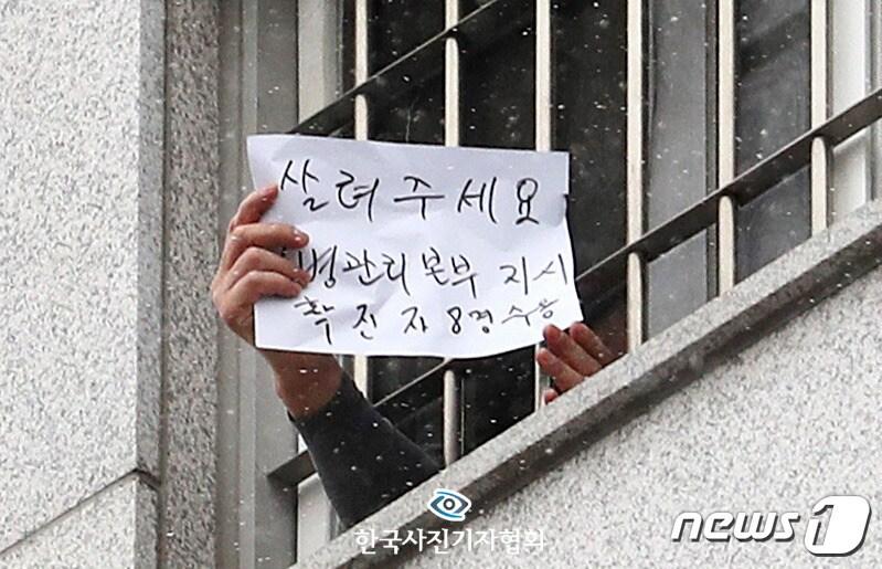 본문 이미지 - <이달의보도사진상 - 최우수상> 대규모 집단감염이 발생한 서울 동부구치소에서 233명이 추가 확진되면서 누적 확진자가 761명으로 집계된 29일 해당 구치소 수용자가 '살려주세요'라고 쓴 피켓을 쇠창살 밖으로 들어 보이고 있다. <이성철기자/ 뉴스1/ 한국사진기자협회 - 무단전재 재배포금지>