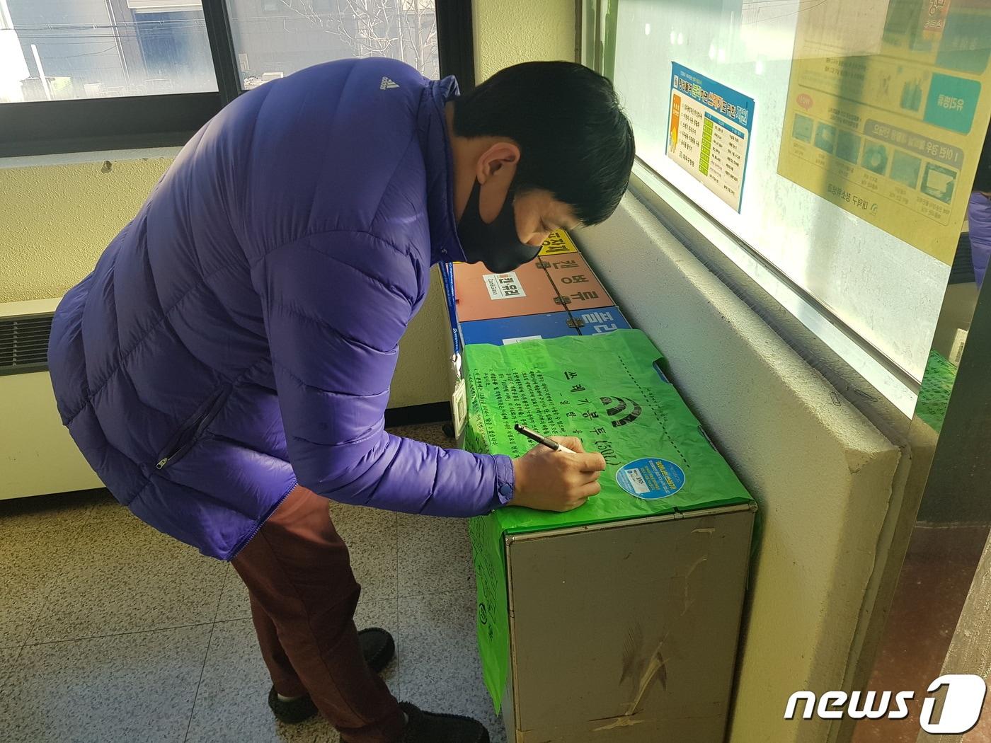 본문 이미지 - 대덕구청 소속 직원이 종량제봉투 부서실명제 스티커에 부서명을 기재하고 있다.(대전 대덕구청 제공)ⓒ 뉴스1