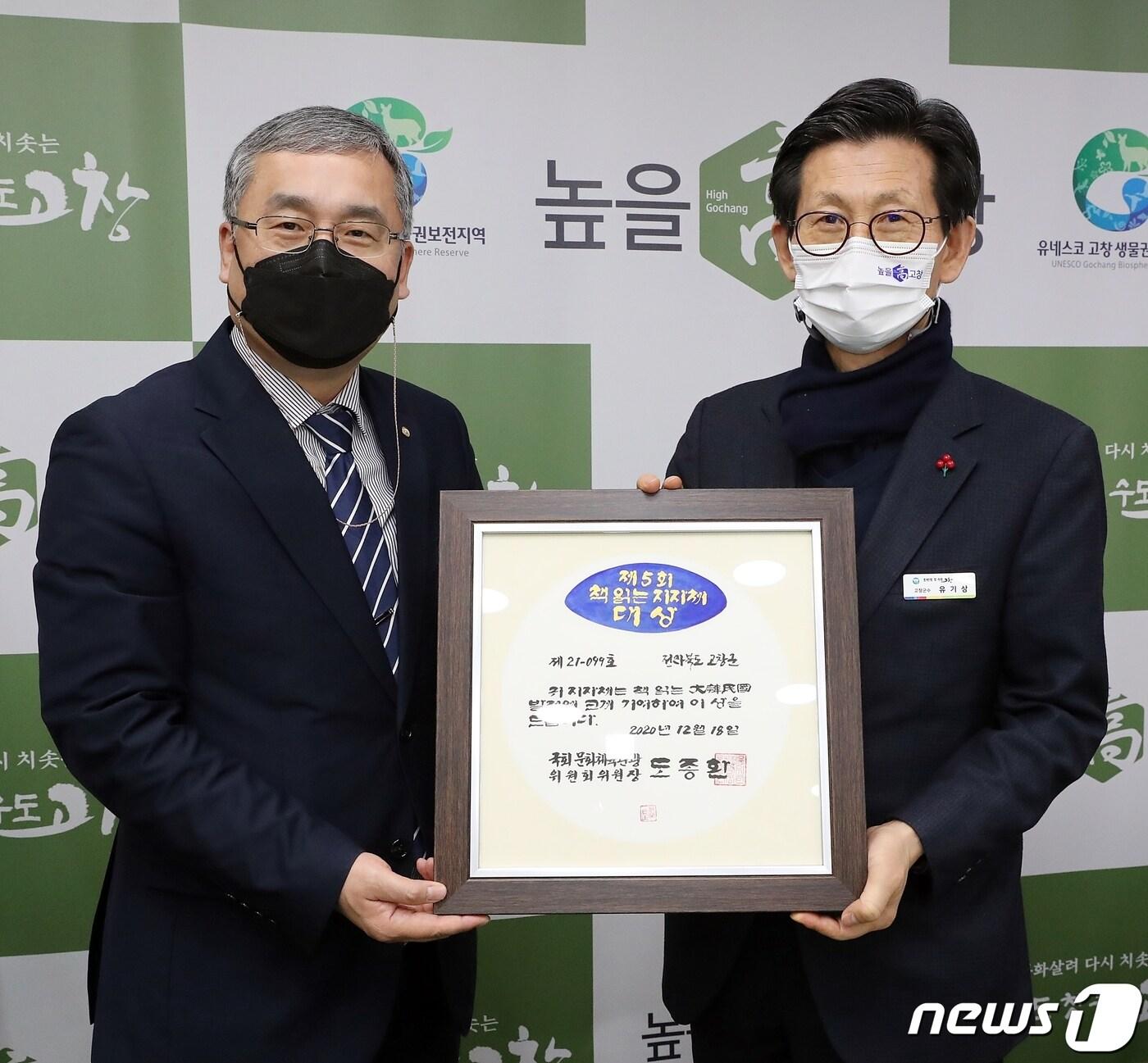 본문 이미지 - 전북 고창군이 ‘대한민국 책읽는 지자체 대상’을 2년 연속 수상했다. 유기상 고창군수(오른쪽)가국민독서문화진흥회 관계자로부터 상패를 받고 있다.ⓒ 뉴스1