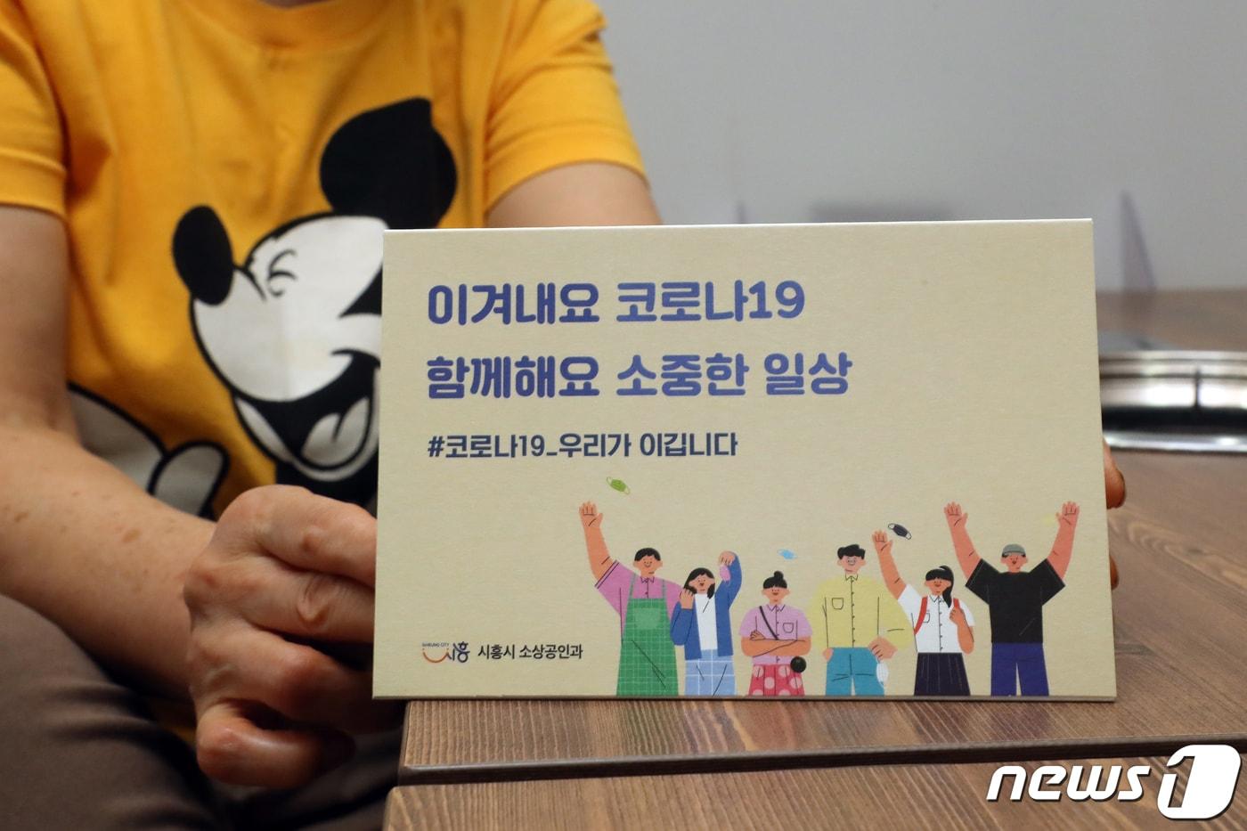 본문 이미지 - 13일 오전 경기 시흥시의 한 식당에서 소상공인이 '일상회복' 홍보물을 문에 붙이며 영업준비를 하고 있다. 2021.10.13/뉴스1 ⓒ News1 황기선 기자
