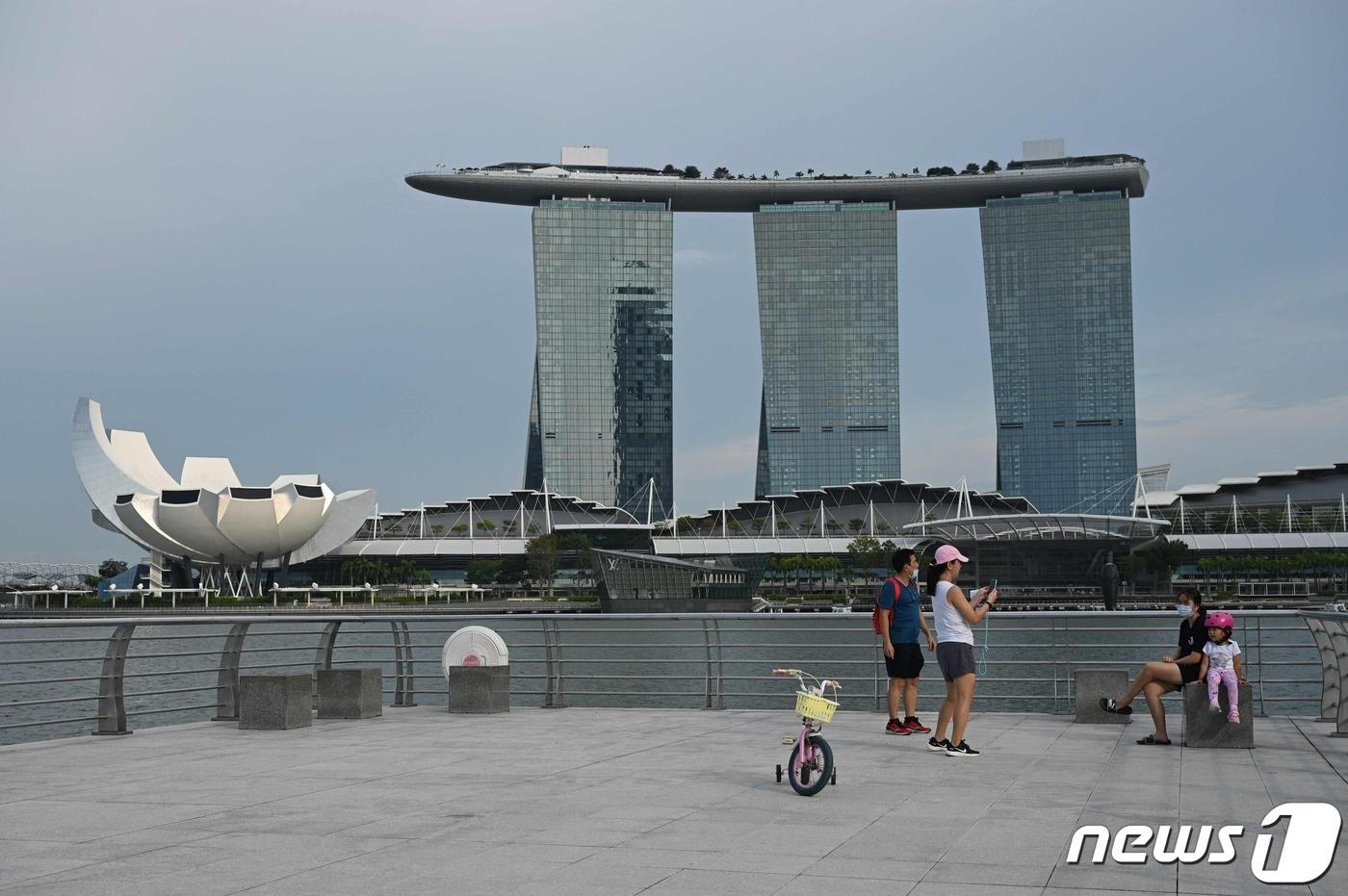 싱가포르 정부는 아직 코로나19 백신 부스터샷을 맞지 않은 60세 이상 국민에게 접종을 당부했다. 사진은 싱가포르 랜드마크인 마리나베이샌즈 호텔이 보이는 공원 모습. 2021. 10. 13. ⓒ AFP=뉴스1