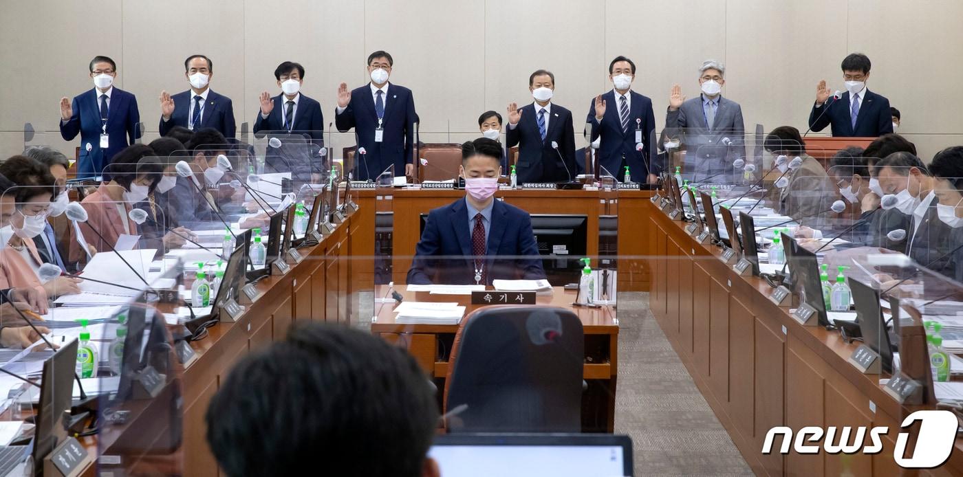본문 이미지 - 권순만 한국보건산업진흥원장(오른쪽) 등 참석자들이 14일 국회에서 보건복지위원회 국정감사에서 증인선서를 하고 있다. 오른쪽부터 권 원장, 정창현 한국한의약진흥원장, 한광협 한국보건의료연구원장, 신희영 대한적십자사 회장, 조현장 한국건강증진개발원장, 정기현 국립중앙의료원장, 윤정석 한국의료분쟁조정중재원장, 임영진 의료기관평가인증원장. 2021.10.14/뉴스1 ⓒ News1 오대일 기자