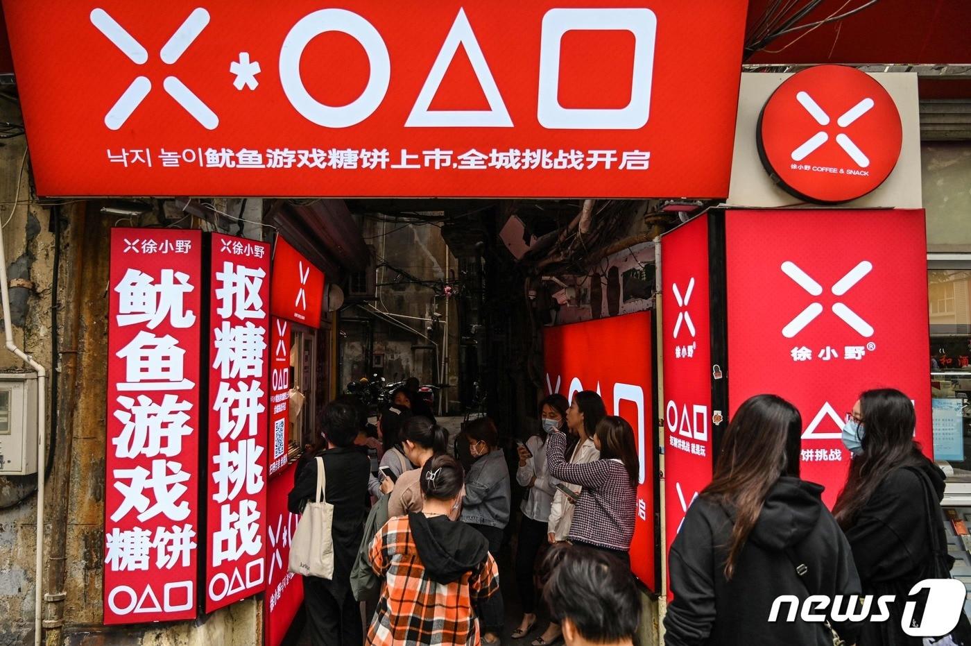 12일 중국 상하이에서 넷플릭스 드라마 ‘오징어 게임’을 테마로 한 달고나 가게에 손님들이 줄을 서서 기다리고 있다. ⓒ AFP=뉴스1 ⓒ News1 우동명 기자