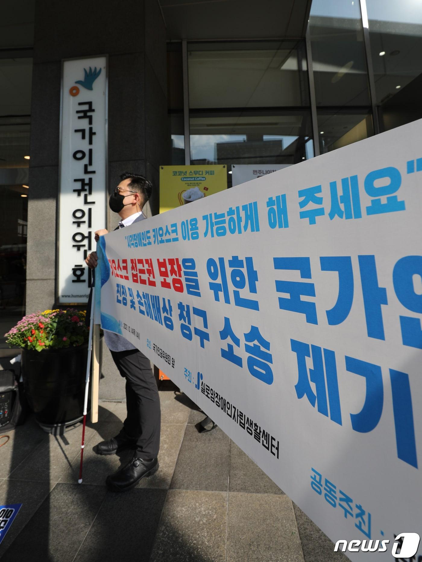 본문 이미지 - 시각장애인이 14일 오후 서울 중구 국가인권위원회 앞에서 키오스크 접근성 보장을 위한 국가인권위원회 진정 및 손해배상 청구 소송 제기 기자회견을 갖고 있다. 2021.10.14/뉴스1 ⓒ News1 박지혜 기자