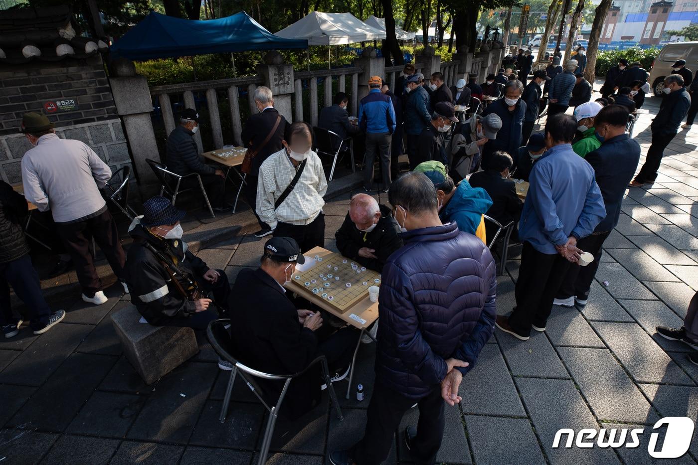 본문 이미지 - 어르신들이 지난 19일 서울 종로구 탑골공원 인근에 모여 장기를 두고 있다./뉴스1 ⓒ News1 유승관 기자