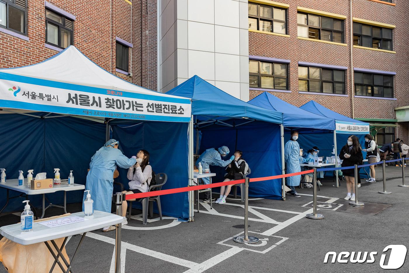 본문 이미지 - 2022학년도 대학수학능력시험을 앞두고 선별진료소 운영을 희망한 건대부속고등학교에 설치된 ‘서울시 찾아가는 선별진료소’에서 학생들과 교직원 등이 검체 검사를 받고 있다. (광진구 제공) 2021.10.20/뉴스1