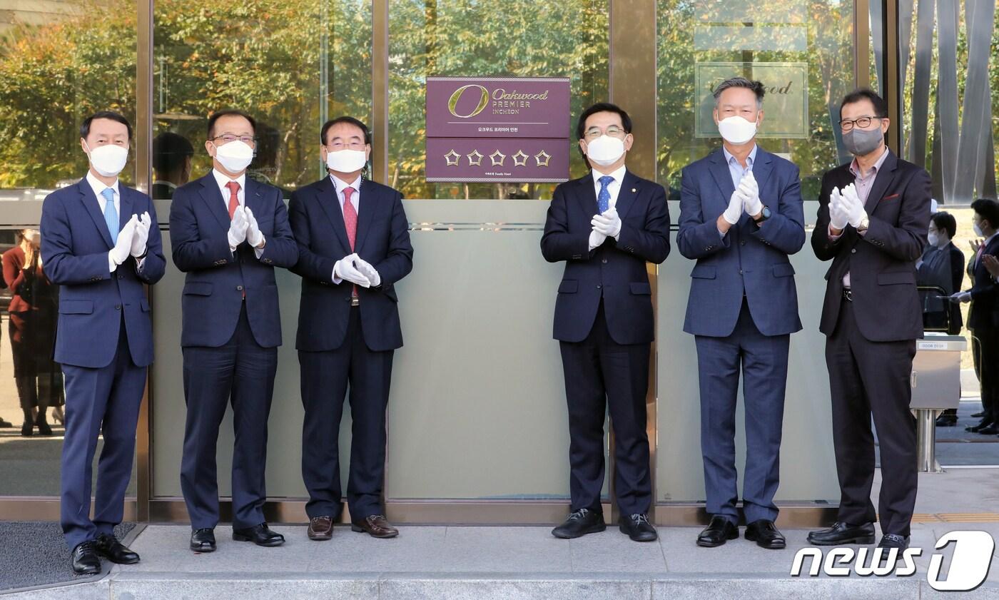 한무컨벤션(주)에서 운영하는 오크우드 프리미어 인천이 한국관광협회중앙회가 시행하는 호텔 등급심사에서 가족호텔로서 최초로 최고 등급인 5성 등급을 획득했다. 22일 심영철 오크우드 프리미어 인천 총지배인, 주시보 ㈜포스코인터내셔널 사장, 조윤영 한무컨밴션㈜ 사장, 더불어민주당 정일영 국회의원, 민민홍 인천관광공사 사장 ,이임혁 인천시관광협회 회장(사진 왼쪽부터)이 오크우드 프리미어 호텔 앞에서 현판식을 하고 있다. 2021.10.22/뉴스1 ⓒ News1 정진욱 기자