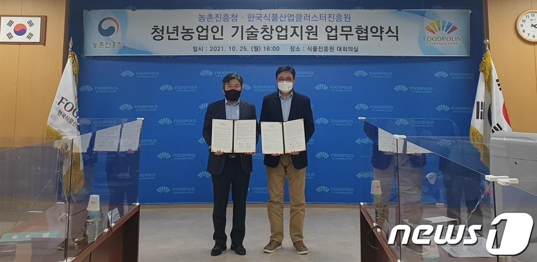 본문 이미지 - 농촌진흥청과 한국식품산업클러스터진흥원(이하 식품진흥원)이 25일 청년농업인의 농식품 분야 기술창업 지원을 위한 업무협약을 체결했다. 업무협약식에서 김영재 식품진흥원 이사장(오른쪽)과 이천일 농촌진흥청 농촌지원국장이 기념 촬영하고 있다. ⓒ 뉴스1