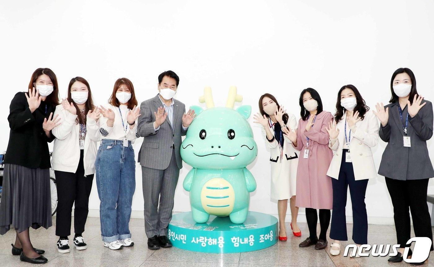 용인시 청사 1층 포토존에 설치된 시 소셜캐릭터 조아용 조형물 앞에서 백군기 시장과 공보관실 직원들이 기념사진을 찍고 있다.(용인시 제공) ⓒ News1  