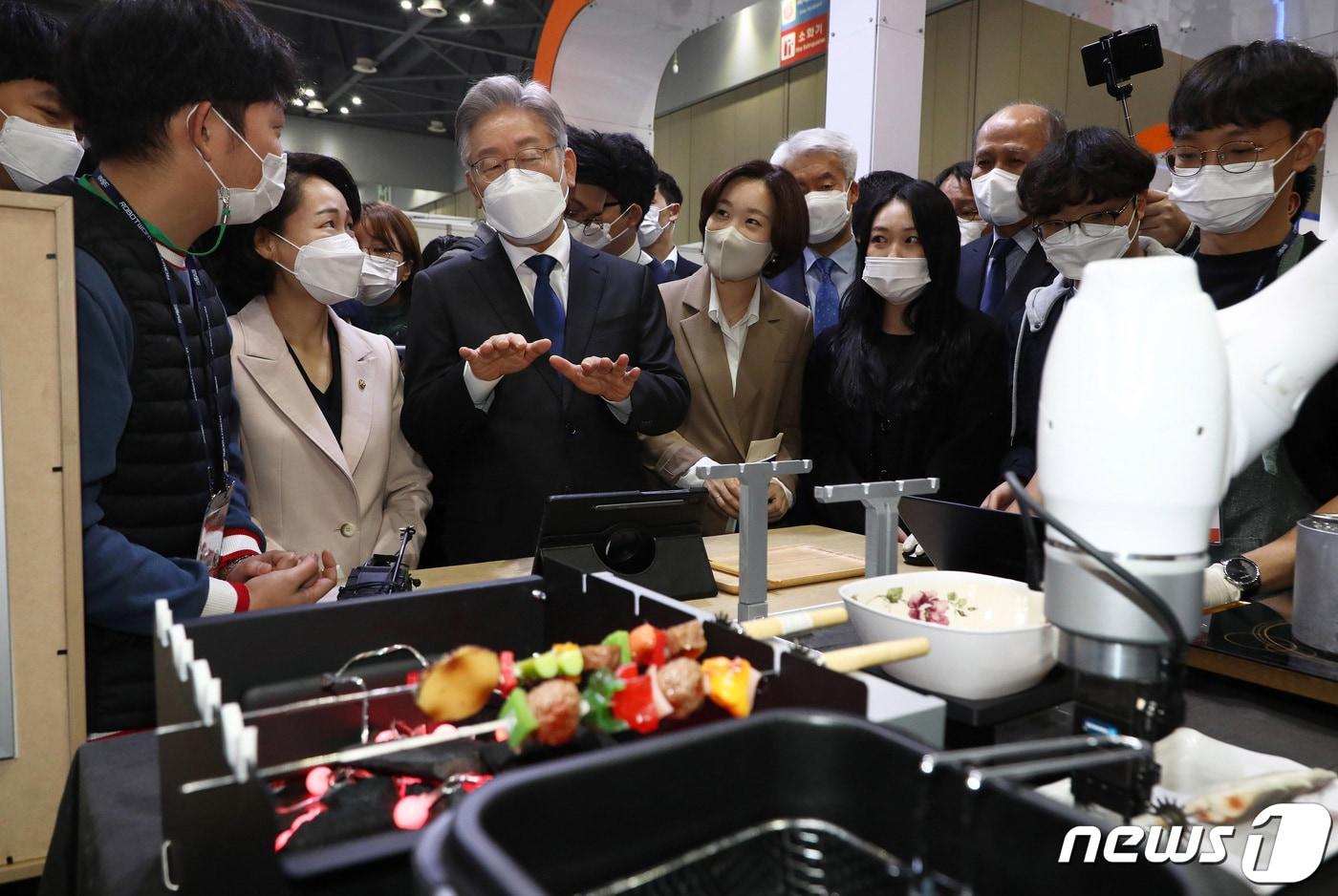 이재명 더불어민주당 대선 후보가 28일 경기도 고양시 킨텍스에서 열린 '2021 로보월드'에서 협동로봇 활용 프로젝트관의 로봇을 살펴보고 있다. 이후 이 후보는 기자들과 만난 자리에서 음식점 주인들을 '불나방'에 비유, 야권으로부터 맹폭을 당했다. ⓒ News1 국회사진취재단