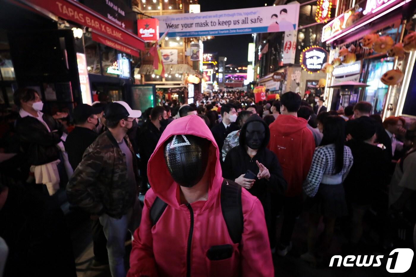 본문 이미지 - 핼러윈 데이를 하루 앞둔 30일 서울 용산구 세계음식거리에서 한 시민이 '오징어게임' 복장을 하고 있다. 2021.10.30/뉴스1 ⓒ News1 이성철 기자