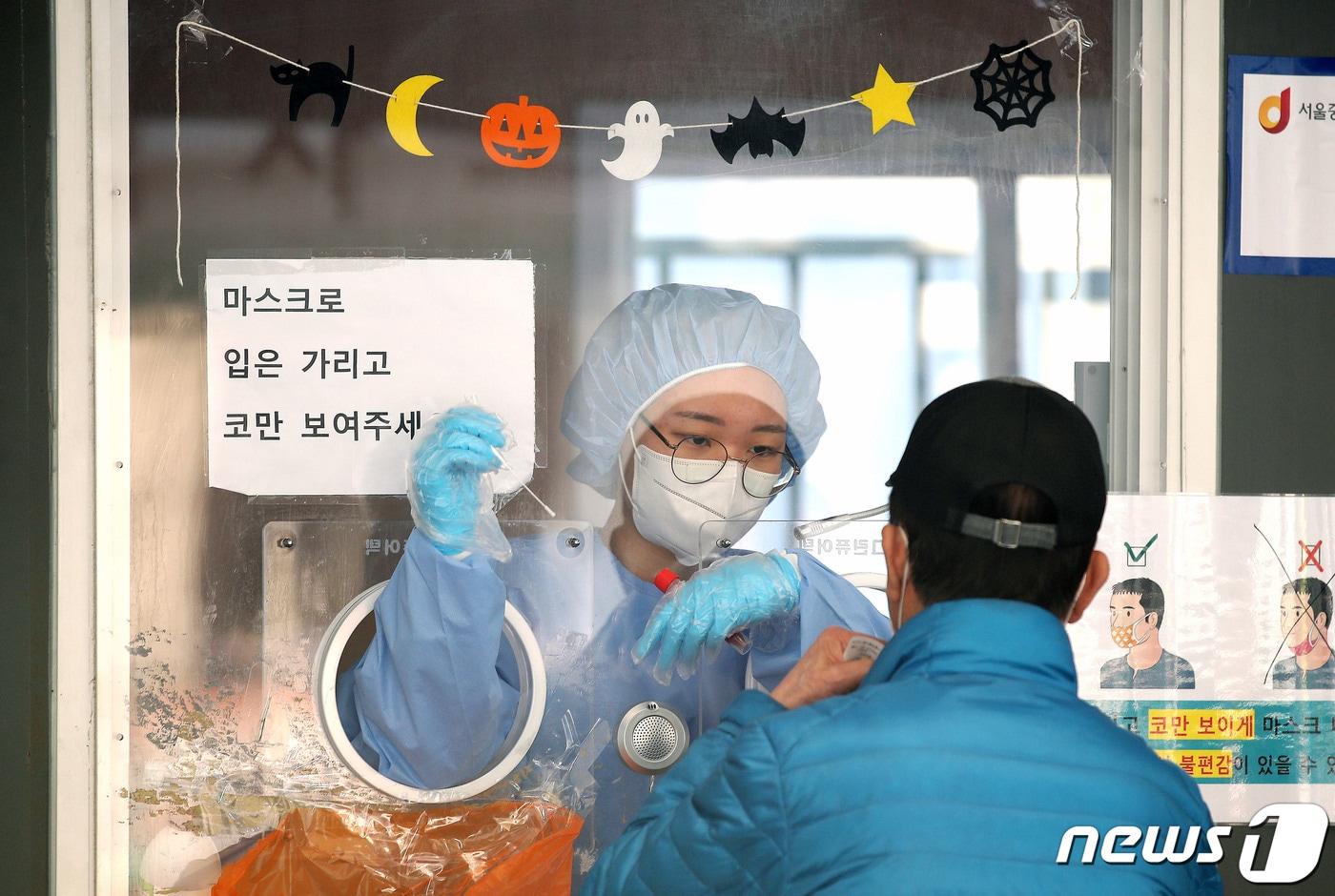 본문 이미지 - 31일 오전 서울역광장에 마련된 신종 코로나바이러스 감염증(코로나19) 중구 임시선별검사소에서 한 시민이 검사를 받고 있다. 이날 0시 기준 코로나19 신규 확진자가 2061명 발생했다고 밝혔다. 10월 중순 안정세를 보이던 유행은 지난 28일 2111명을 기록한 이후 나흘 연속 2000명대를 유지했다. 2021.10.31/뉴스1 ⓒ News1 임세영 기자