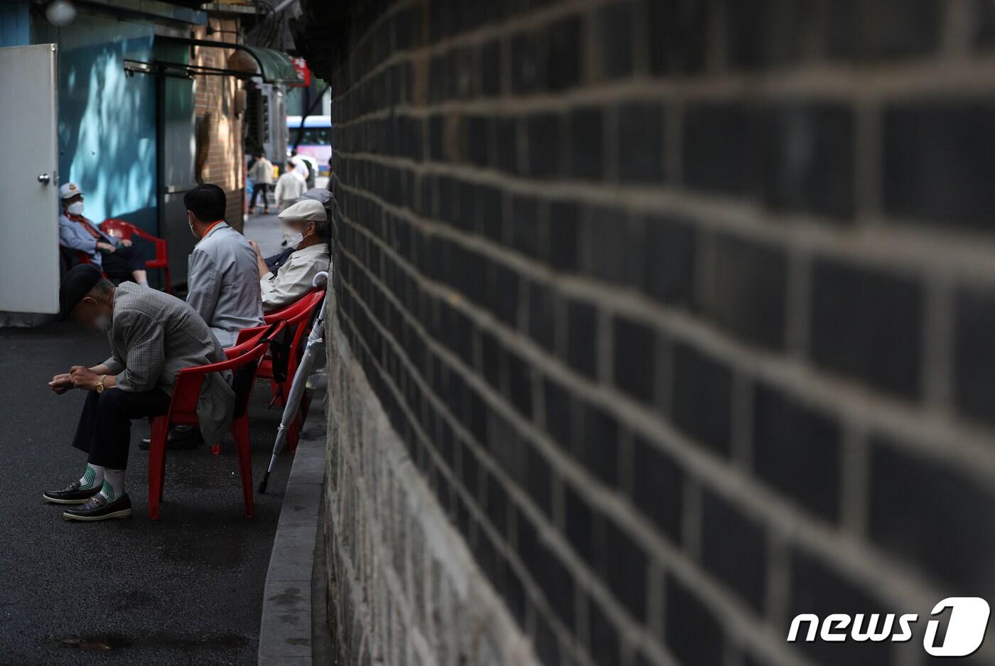 본문 이미지 - 서울 종로구 탑골공원 담장에 기대어 어르신들이 휴식을 취하고 있다.  2021.10.6/뉴스1 ⓒ News1 신웅수 기자