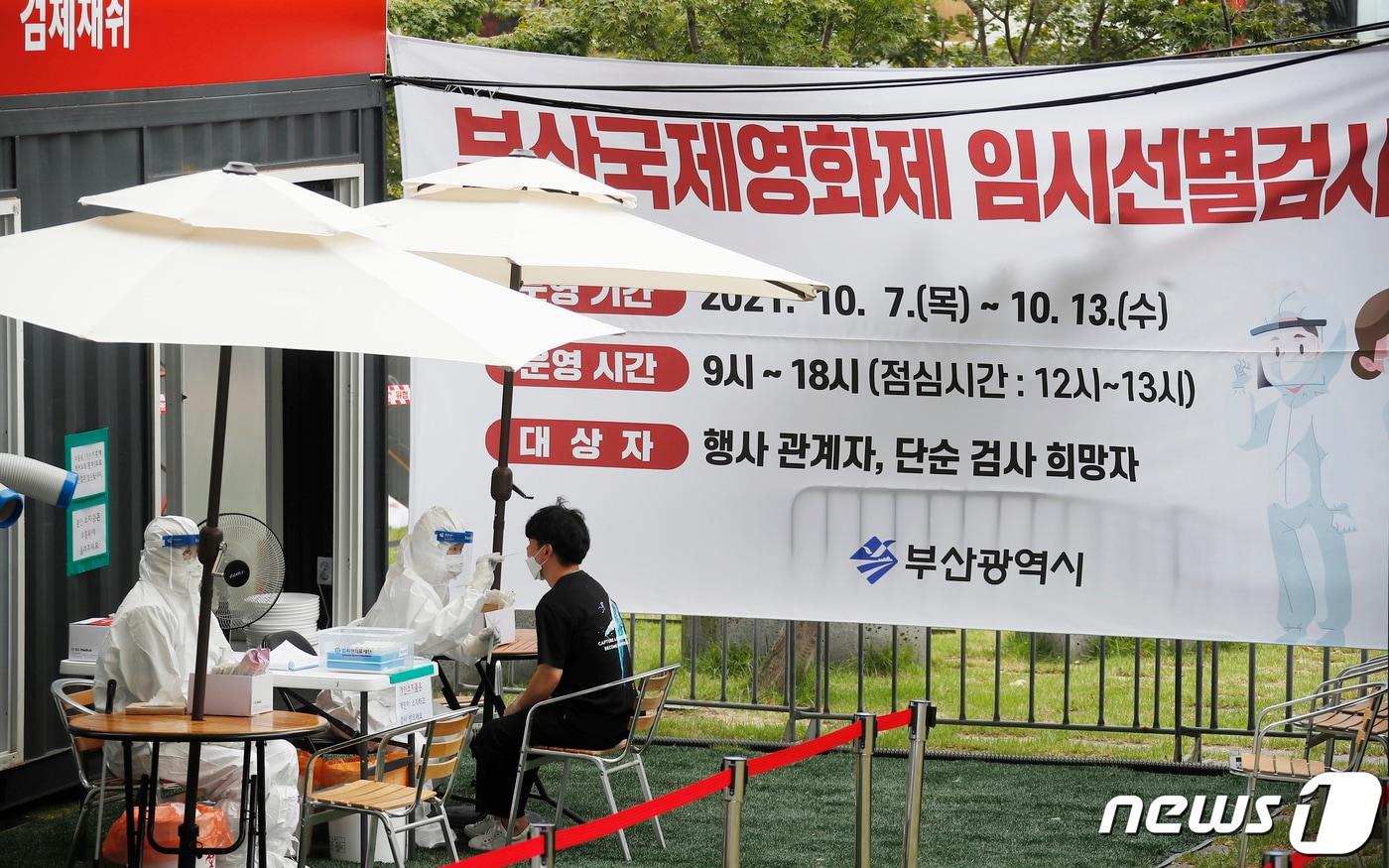 제26회 부산국제영화제 삼일 째인 8일 부산 해운대구 영화의전당 야외에 설치된 신종 코로나바이러스감염증(코로나19) 임시선별진료소에서 한 시민이 검체채취를 하고 있다. 2021.10.8/뉴스1 ⓒ News1 권현진 기자