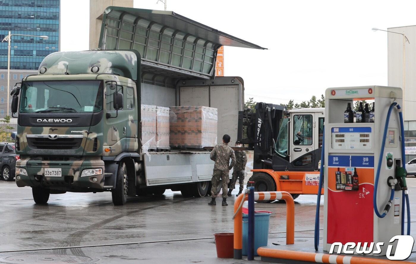 본문 이미지 - 군(軍)이 비축하고 있는 차량용 요소수 예비분이 민간에 공급이 시작된 11일 오전 경기도 평택시 평택항 인근의 주유소에 요소수를 실은 군 차량이 도착해 요소수를 하차하고 있다.  2021.11.11/뉴스1 ⓒ News1 김영운 기자