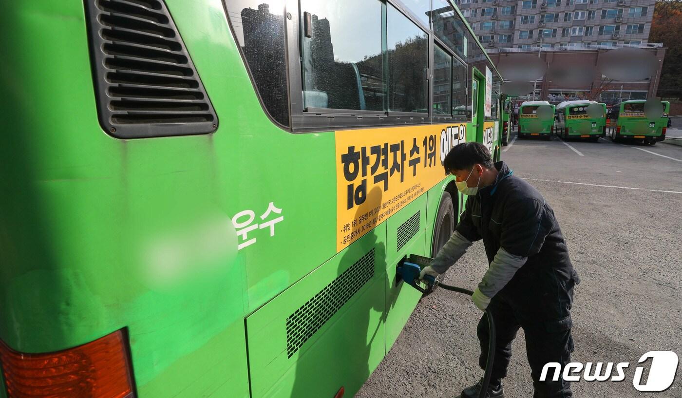 본문 이미지 - 12일 오전 서울의 한 버스운송 업체에서 정비 책임자가 버스에 요소수를 넣고 있다. 2021.11.12/뉴스1 ⓒ News1 성동훈 기자