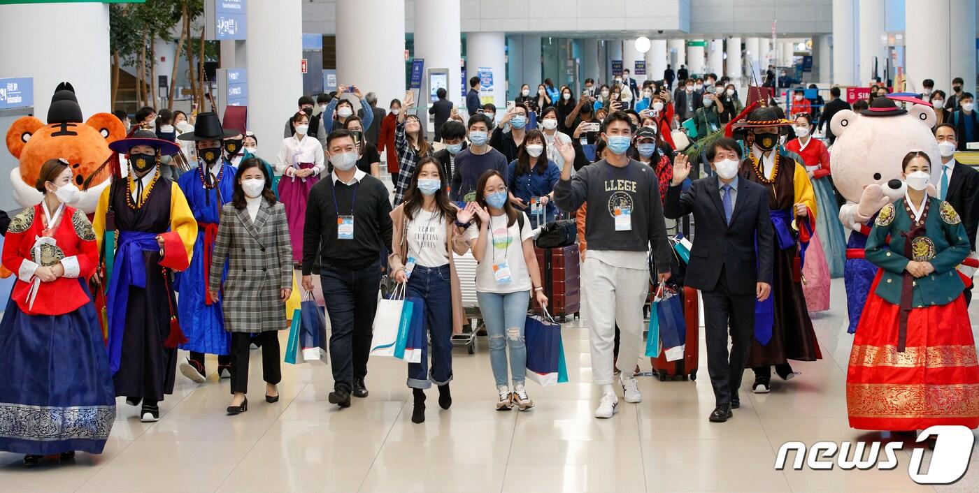 본문 이미지 - 15일 인천국제공항 2터미널을 통해 입국한 싱가포르 관광업계 및 미디어 팸투어단이 환영을 받으며 손을 흔들고 있다. 한국-싱가포르 간 여행안전권역(트래블 버블)이 이날부터 시행됨에 따라 백신 접종을 완료한 양국 국민들은 격리부담 없이 여행을 할 수 있다. 2021.11.15/뉴스1 ⓒ News1 안은나 기자