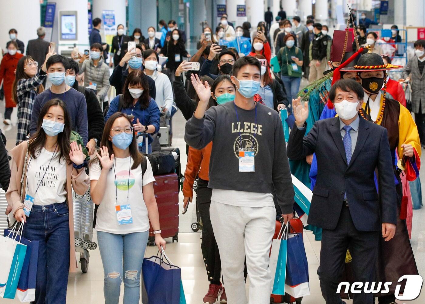 본문 이미지 - 15일 인천국제공항 2터미널을 통해 입국한 싱가포르 관광업계 및 미디어 팸투어단이 환영을 받으며 손을 흔들고 있다. 앞줄 오른쪽 첫번째는 안영배 한국관광공사 사장. 한국-싱가포르 간 여행안전권역(트래블 버블)이 이날부터 시행됨에 따라 백신 접종을 완료한 양국 국민들은 격리부담 없이 여행을 할 수 있다. 2021.11.15/뉴스1 ⓒ News1 안은나 기자