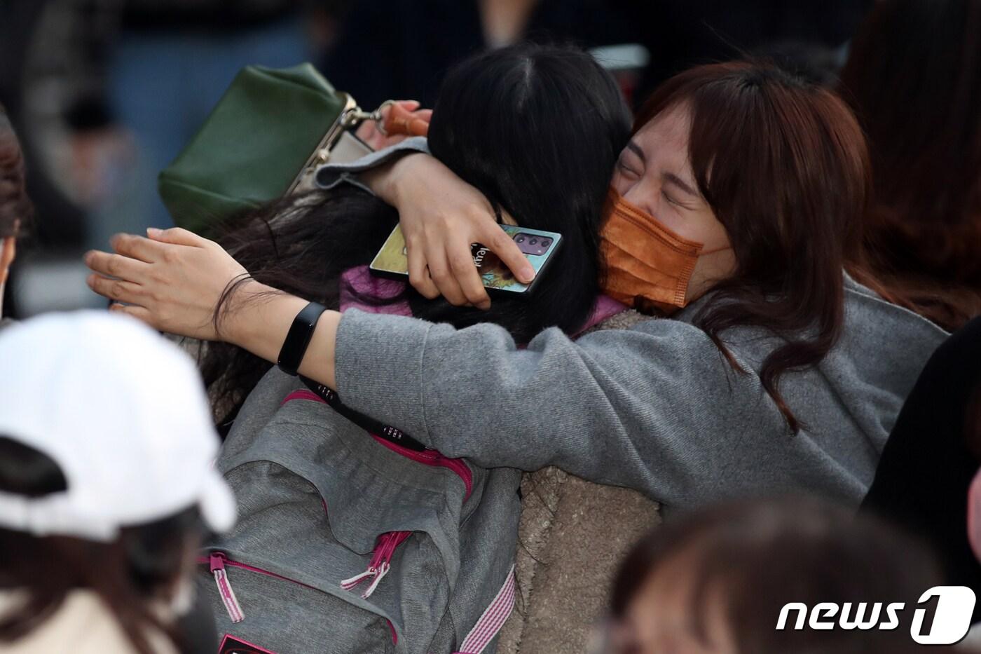 본문 이미지 - 대학수학능력시험일인 18일 광주 한 고등학교에서 수험생이 가족의 격려를 받고 있다. 20211.11.18/뉴스1 ⓒ News1 황희규 기자