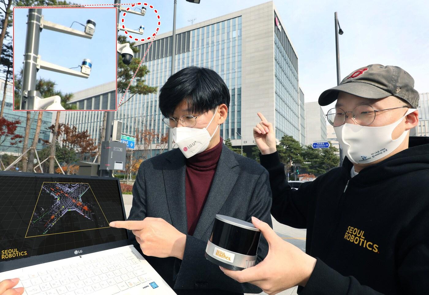 본문 이미지 - LG유플러스 서울 마곡사옥 앞 교차로에 설치된 라이다(LiDAR) 센서를 주영준 LG유플러스 차세대기술랩장(왼쪽)과 이한빈 서울로보틱스 대표가 살펴보고 있는 모습. (LGU+ 제공)