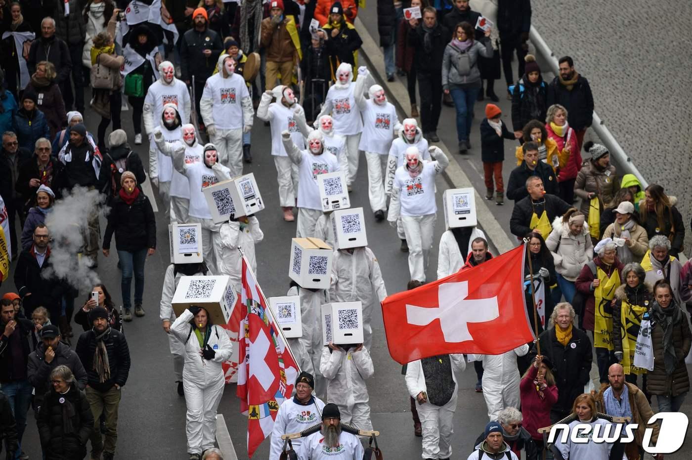 본문 이미지 - 20일(현지시간) 스위스 로잔에서 시민들이 플래카드를 들고 코로나19 봉쇄 조치와백신 접종 의무화에 반대하는 행진을 하고 있다. (본문과 관련없음) ⓒ AFP=뉴스1 ⓒ News1 우동명 기자