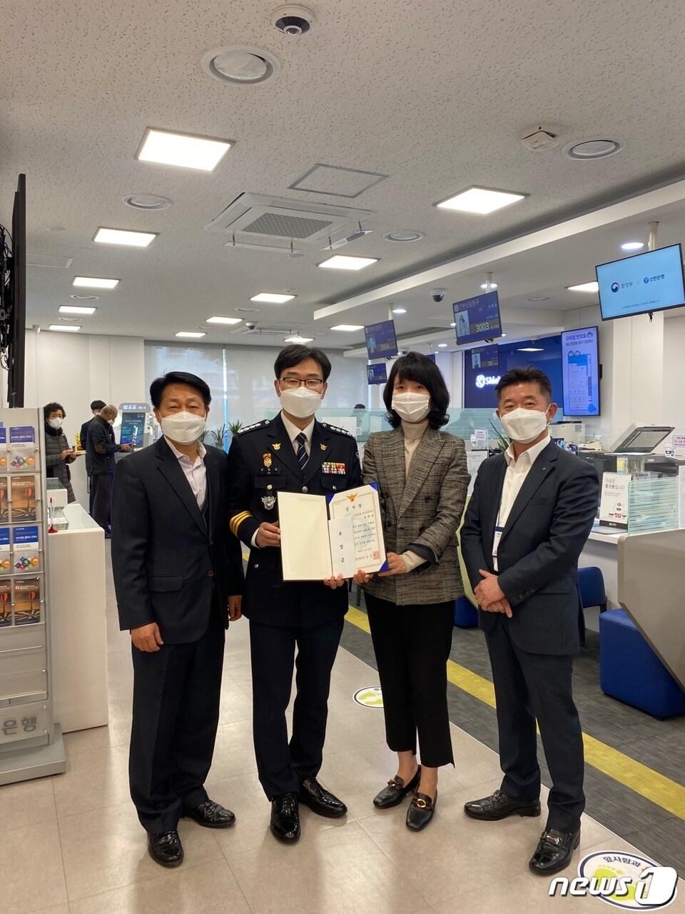 본문 이미지 - 오동욱 마산동부경찰서장이 24일 신한은행 마산금융센터를 찾아 전화금융사기(보이스피싱) 밤죄 피해를 예방한 은행원에게 감사장과 포상금을 전달했다.(마동서 제공)2021.11.24.ⓒ 뉴스1