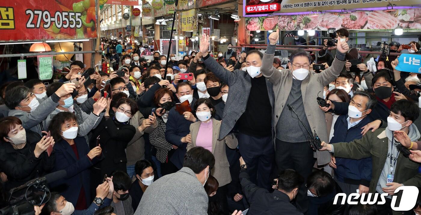 이재명 더불어민주당 대선후보가 26일 오후 전남 목포시 동부시장을 찾아 김원이 국회의원과 함께 시장 상인들에게 큰 목소리로 인사하고 있다. 2021.11.26/뉴스1 ⓒ News1 황희규 기자