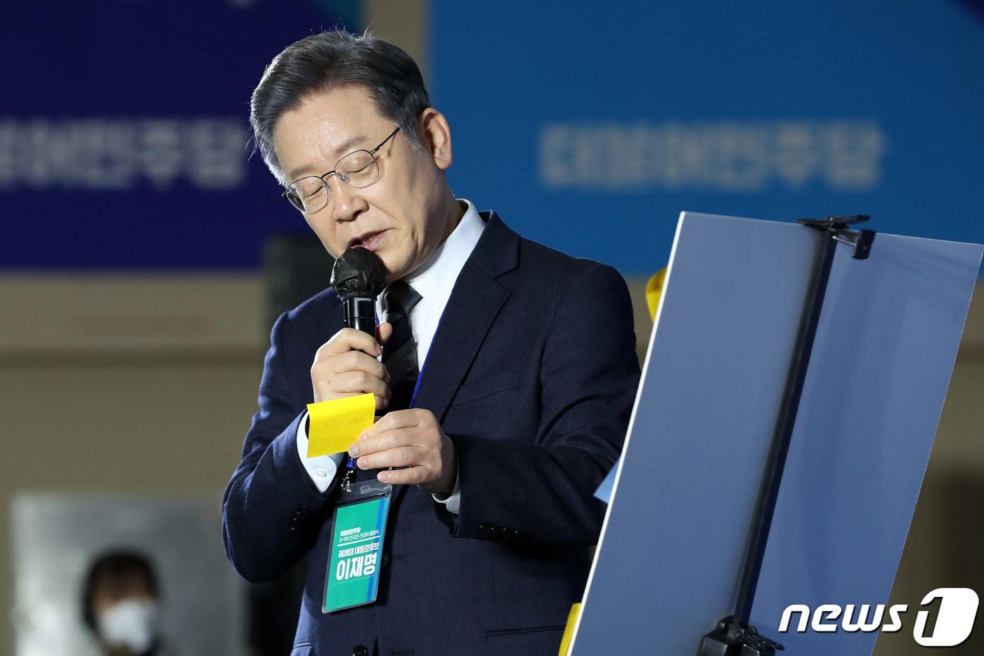 이재명 더불어민주당 대선후보가 29일 오전 광주 서구 김대중컨벤션센터에서 열린 'D-100 전국민 선대위 회의'에서 화이트보드에 붙은 질문지를 읽고 있다. 2021.11.29/뉴스1 ⓒ News1 이동해 기자