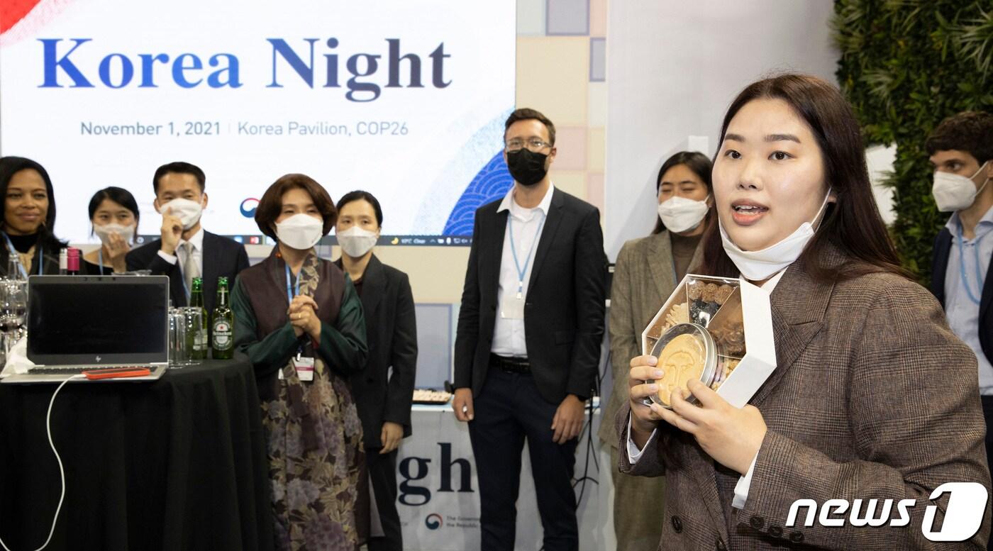 코리안 나이트에서 달고나를 들어 보이는 환경부 관계자. 한정애 환경장관도 웃으며 행사에 참석하고 있다. (사진제공=환경부) ⓒ 뉴스1