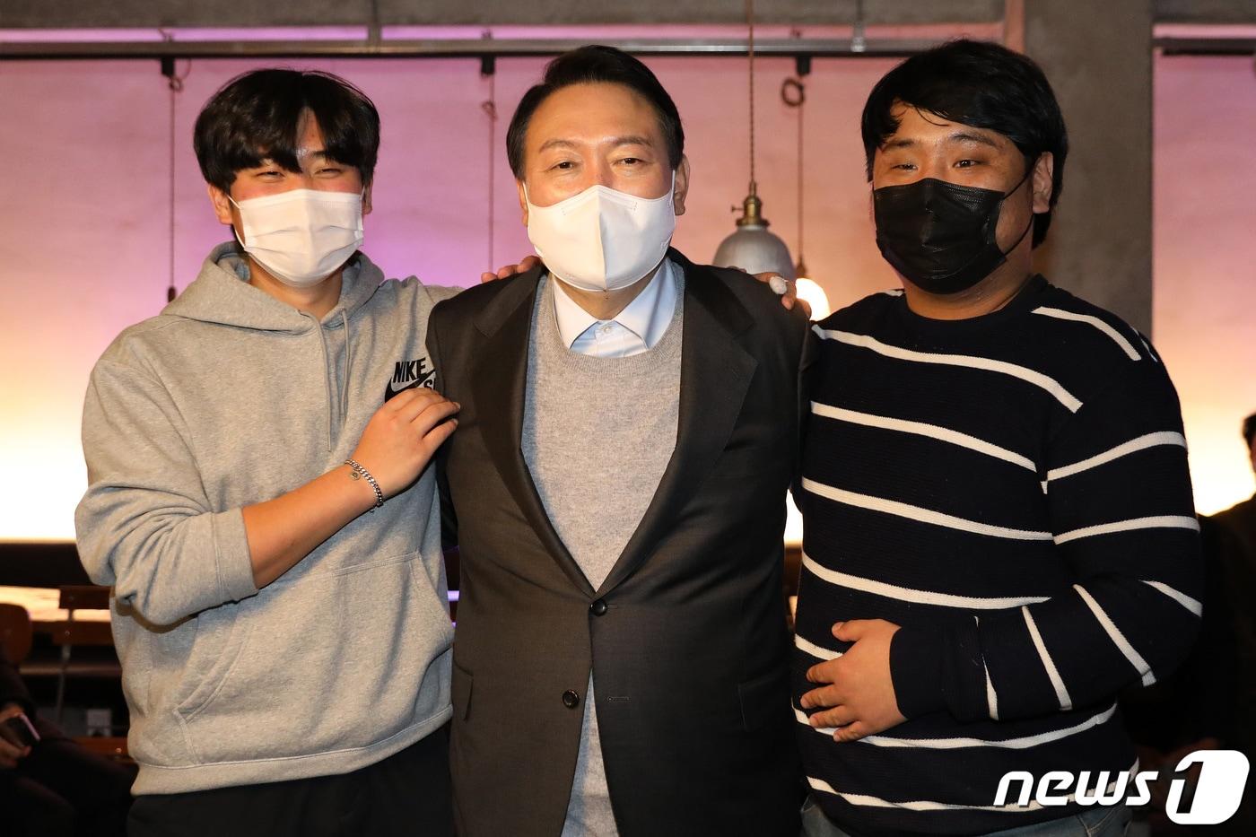 본문 이미지 - 윤석열 국민의힘 대선 후보가 10일 저녁 강릉 안목동의 한 카페을 찾아 지난 19년 시내에서 흉기 난동범을 맨손으로 제압한 전중현, 변정우 씨를 만나 기념사진 찍고 있다. 2021.12.10/뉴스1 ⓒ News1 이동해 기자