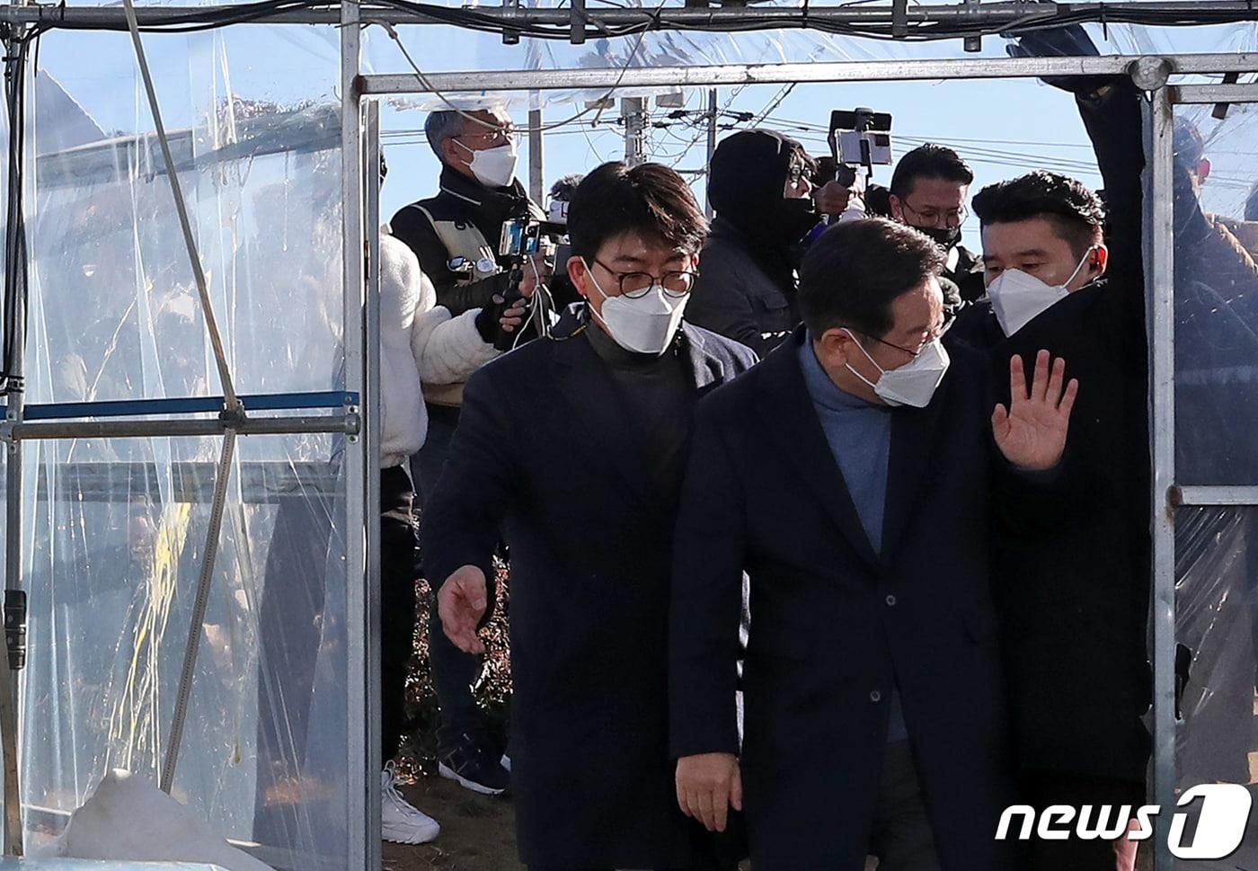 이재명 더불어민주당 대선 후보가 13일 오전 대구·경북 매타버스 민생투어의 일환으로 경북 성주군의 한 참외 농가를 방문하다 사드 배치를 반대하는 지역 주민이 던진 계란이 날아들자 경호원에게 괜찮다며 손짓하고 있다. 사진 왼쪽 비닐하우스 외벽에 깨진 계란 자국이 보인다. 2021.12.13/뉴스1 ⓒ News1 오대일 기자