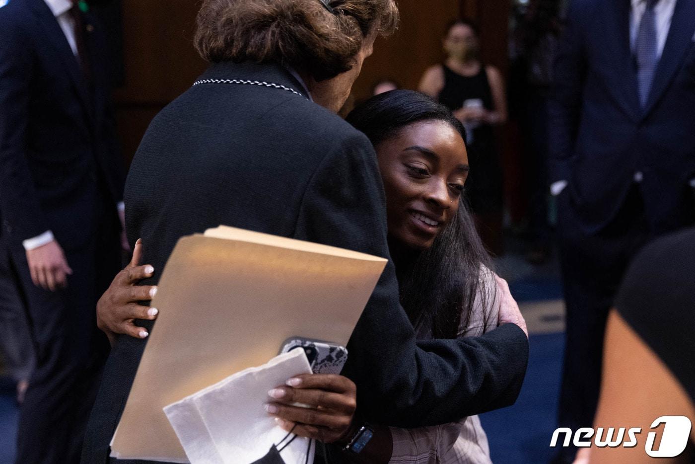시몬 바일스가 지난 9월 15일 미 상원 청문회에 출석해 래리 나사르 사건과 관련한 증언을 끝마친 뒤 관계자와 포옹하고 있다. ⓒ AFP=뉴스1 ⓒ News1 김지현 기자