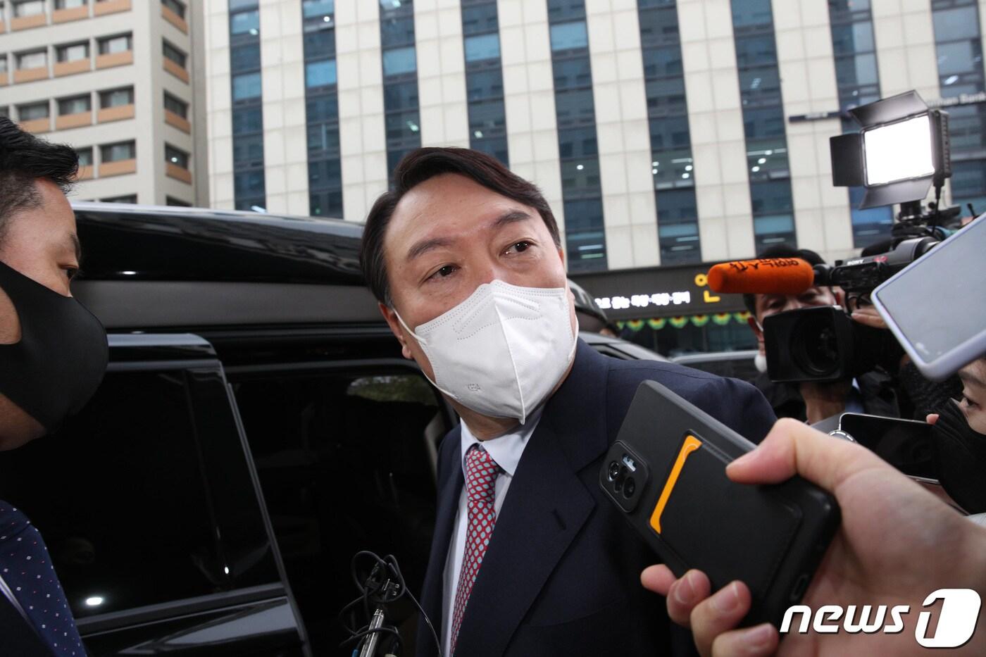 윤석열 국민의힘 대선 후보가 16일 오전 배우자인 김건희 씨의 '허위 이력' 논란과 관련한 취재진의 질문을 들으며 서울 여의도 새시대준비위원회 사무실을 나서고 있다. 2021.12.16/뉴스1 ⓒ News1 구윤성 기자