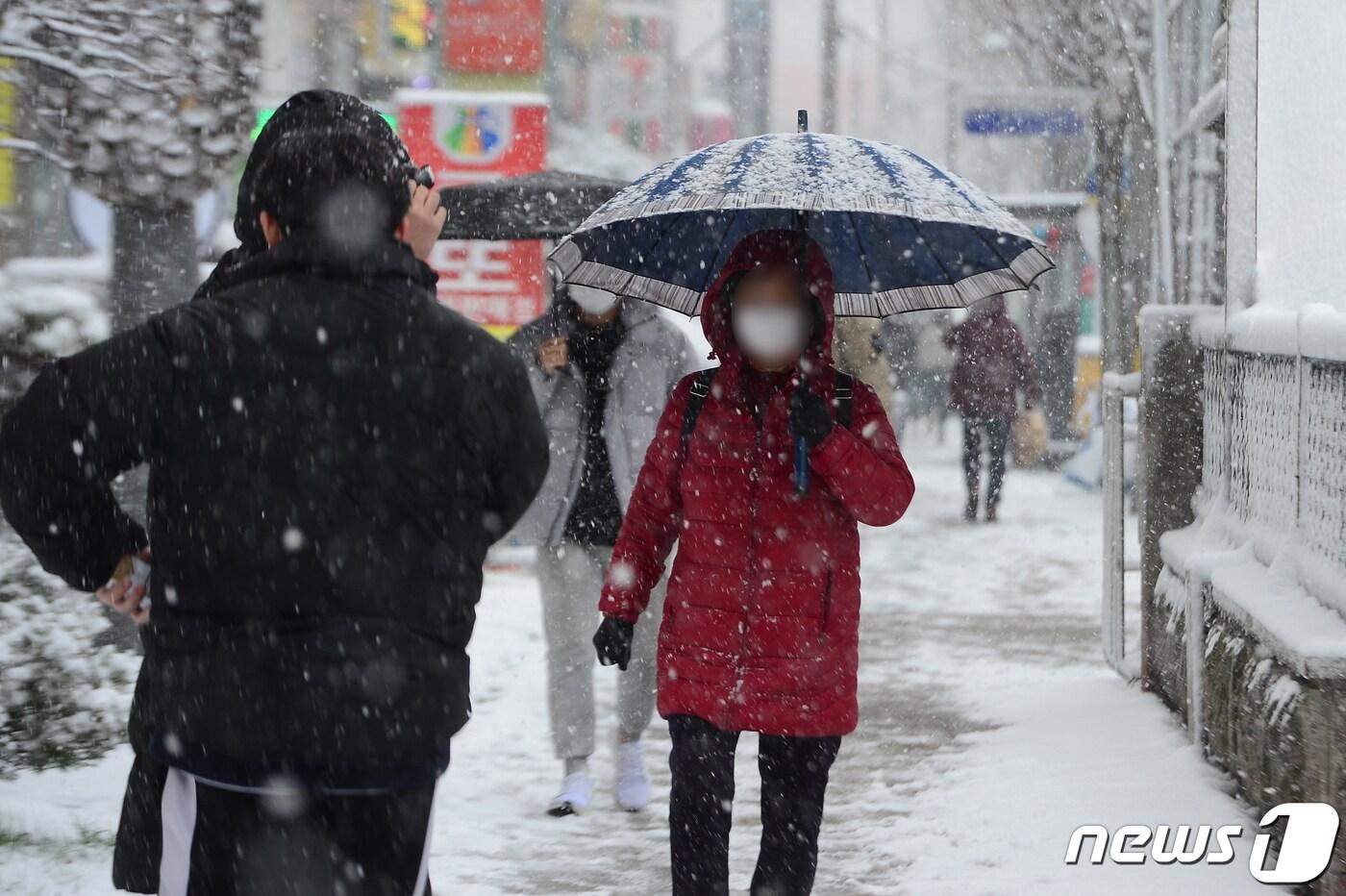 본문 이미지 - 17일 오후 광주 서구 쌍촌동 한 인도에서 시민들이 내리는 눈을 피해 이동하고 있다. 2021.12.17/뉴스1 ⓒ News1 정다움 기자
