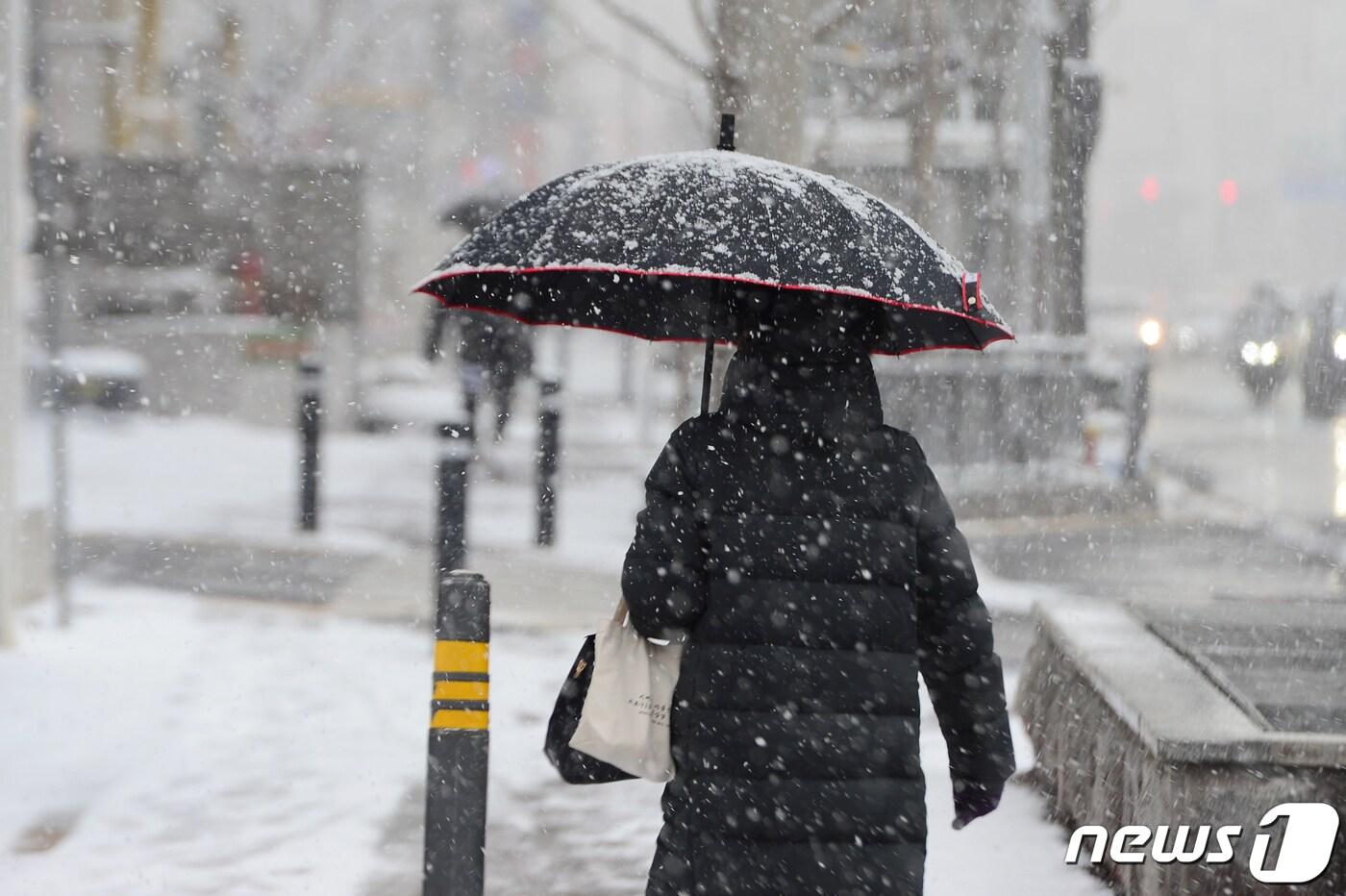 17일 오후 광주 서구 쌍촌동 한 인도에서 시민들이 내리는 눈을 피해 이동하고 있다. 2021.12.17/뉴스1 ⓒ News1 정다움 기자