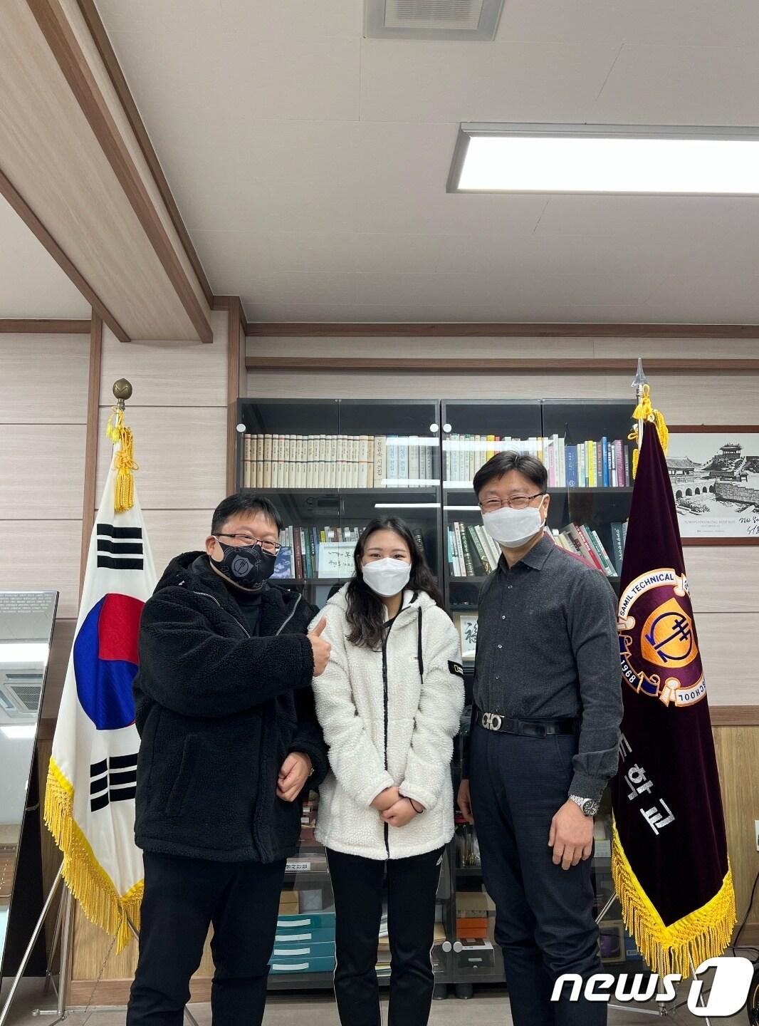 본문 이미지 - 2차 경찰 공무원 시험에 합격한 이성은 학생(가운데)과 김동수 교장(오른쪽), 백찬수 부장교사가 기념촬영을 하고 있다.(삼일공고 제공)ⓒ 뉴스1