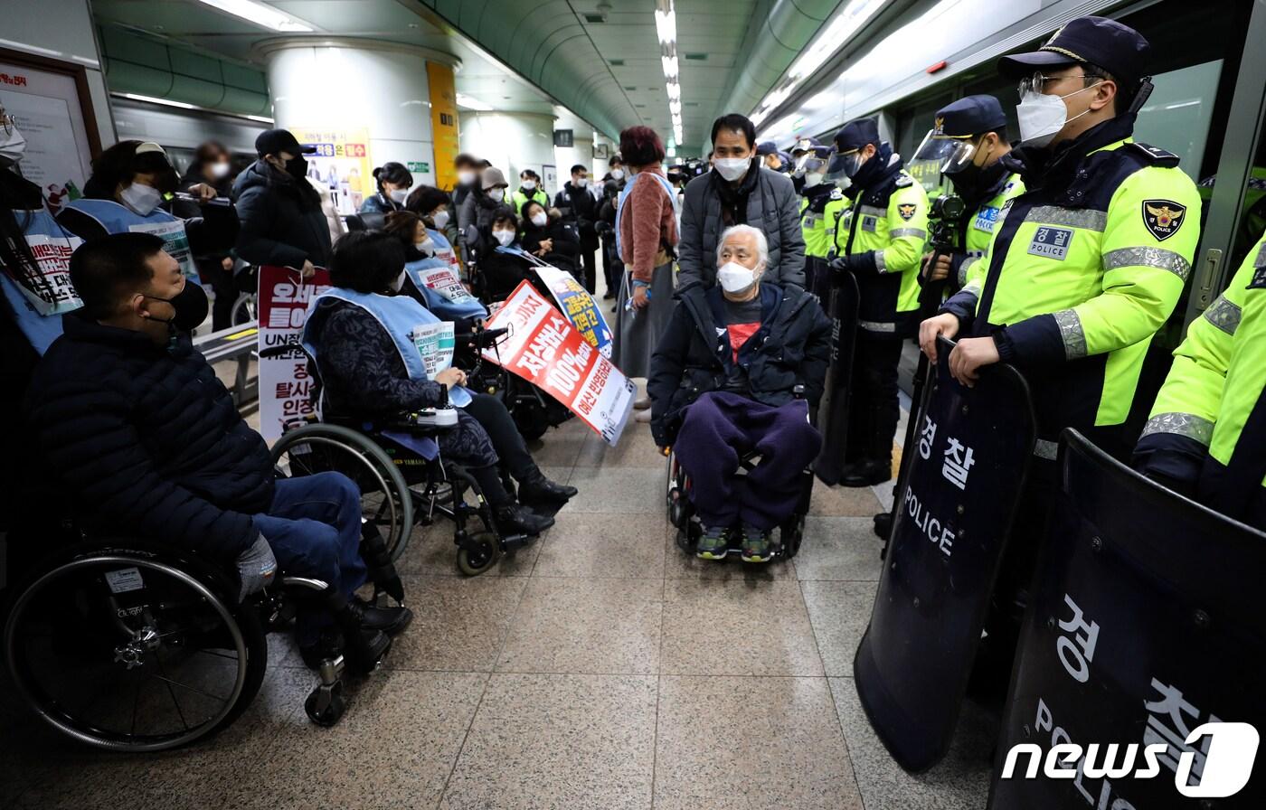 본문 이미지 - 전국 장애인차별철폐연대 회원들이 20일 오전 서울 종로구 지하철 5호선 광화문역에서 장애인 이동권 보장을 촉구하며 공덕역으로 이동하기 위해 집결하고 있다. 2021.12.20/뉴스1 ⓒ News1 이재명 기자