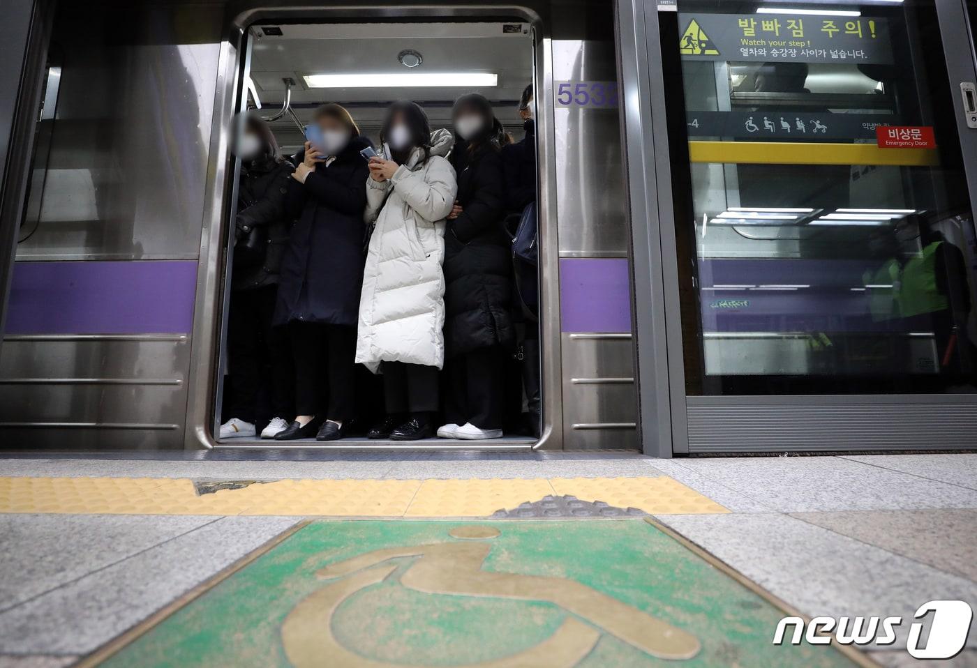 본문 이미지 - 서울 종로구 지하철 5호선 광화문역에서 출근길 시민들이 전국장애인차별철폐연대 회원들의 이동권 보장 촉구 시위에 불편을 겪고 있다. 2021.12.20/뉴스1 ⓒ News1 이재명 기자