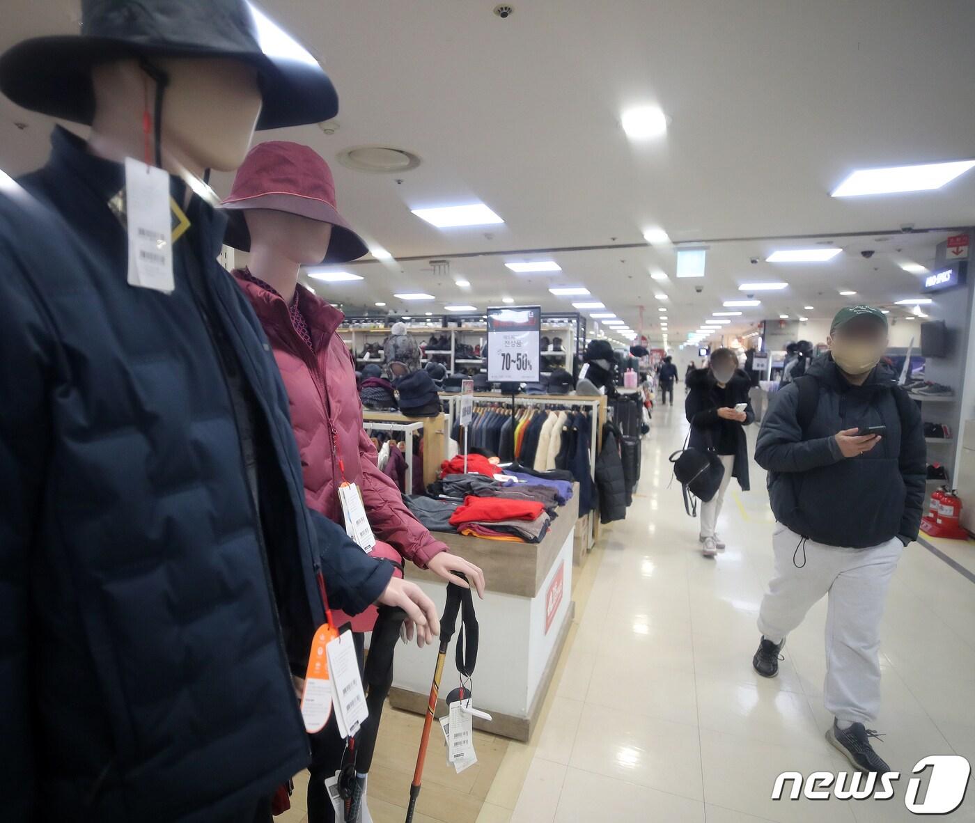 본문 이미지 - 서울 시내 한 대형마트에서 한 시민이 아웃도어 브랜드 매장에 전시된 용품을 보고 있다.2021.12.27/뉴스1 ⓒ News1 김진환 기자