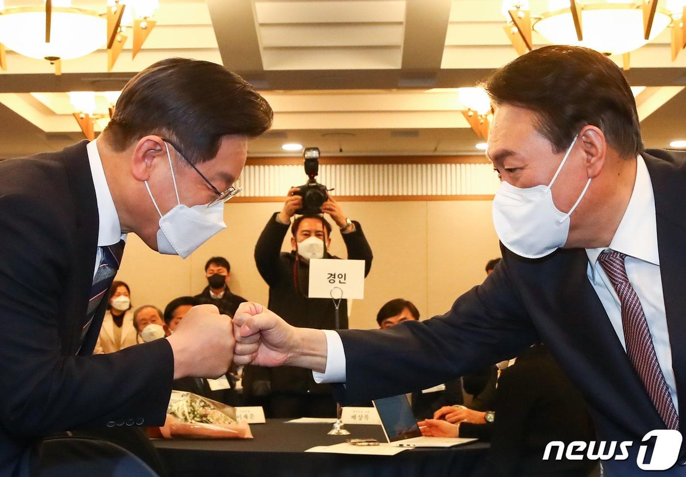 이재명 더불어민주당 대선 후보와 윤석열 국민의힘 대선 후보가 27일 오후 서울 중구 한국프레스센터에서 열린 지방자치대상 및 한국지역발전대상 시상식에서 만나 주먹인사를 나누고 있다. 2021.12.27/뉴스1 ⓒ News1 국회사진취재단