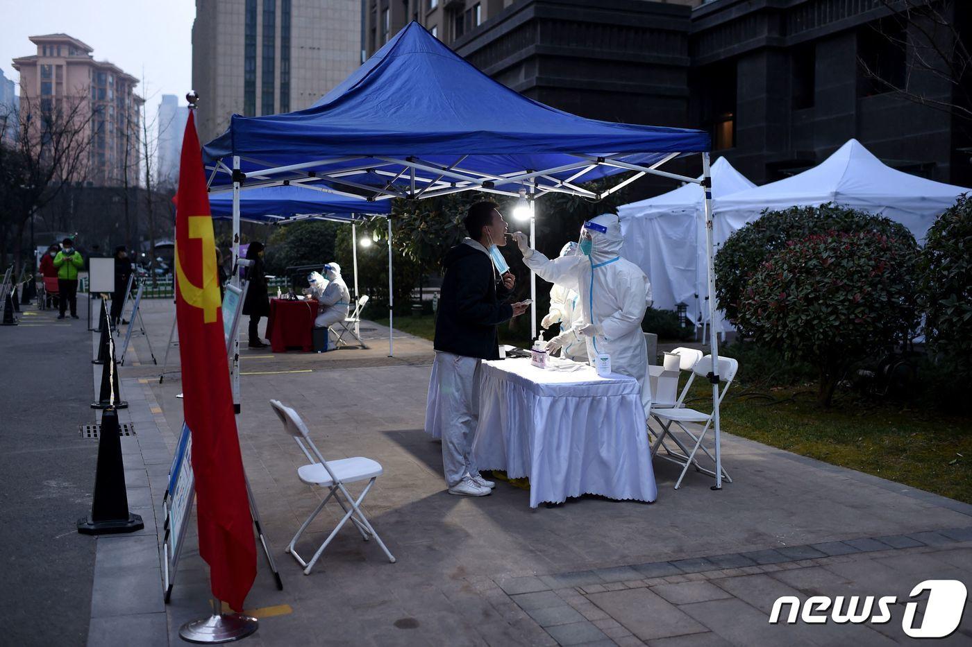 본문 이미지 - 23일(현지시간) 중국 북부 산시상 시안시에서 한 남성이 신종 코로나바이러스(코로나19) 감염증 진단 검사를 받고 있다. ⓒ AFP=뉴스1 ⓒ News1 정윤미 기자