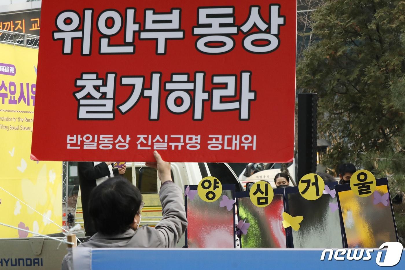 본문 이미지 - 지난해 말 서울 중학동 옛 일본대사관 앞에서 열린 '제1524차 일본군성노예제 문제 해결을 위한 정기 수요시위'에서 참석자들이 수요집회 중단과 소녀상 철거 등을 주장하는 단체와 '양심거울'을 들고 대치하고 있다. 2021.12.15/뉴스1 ⓒ News1 민경석 기자