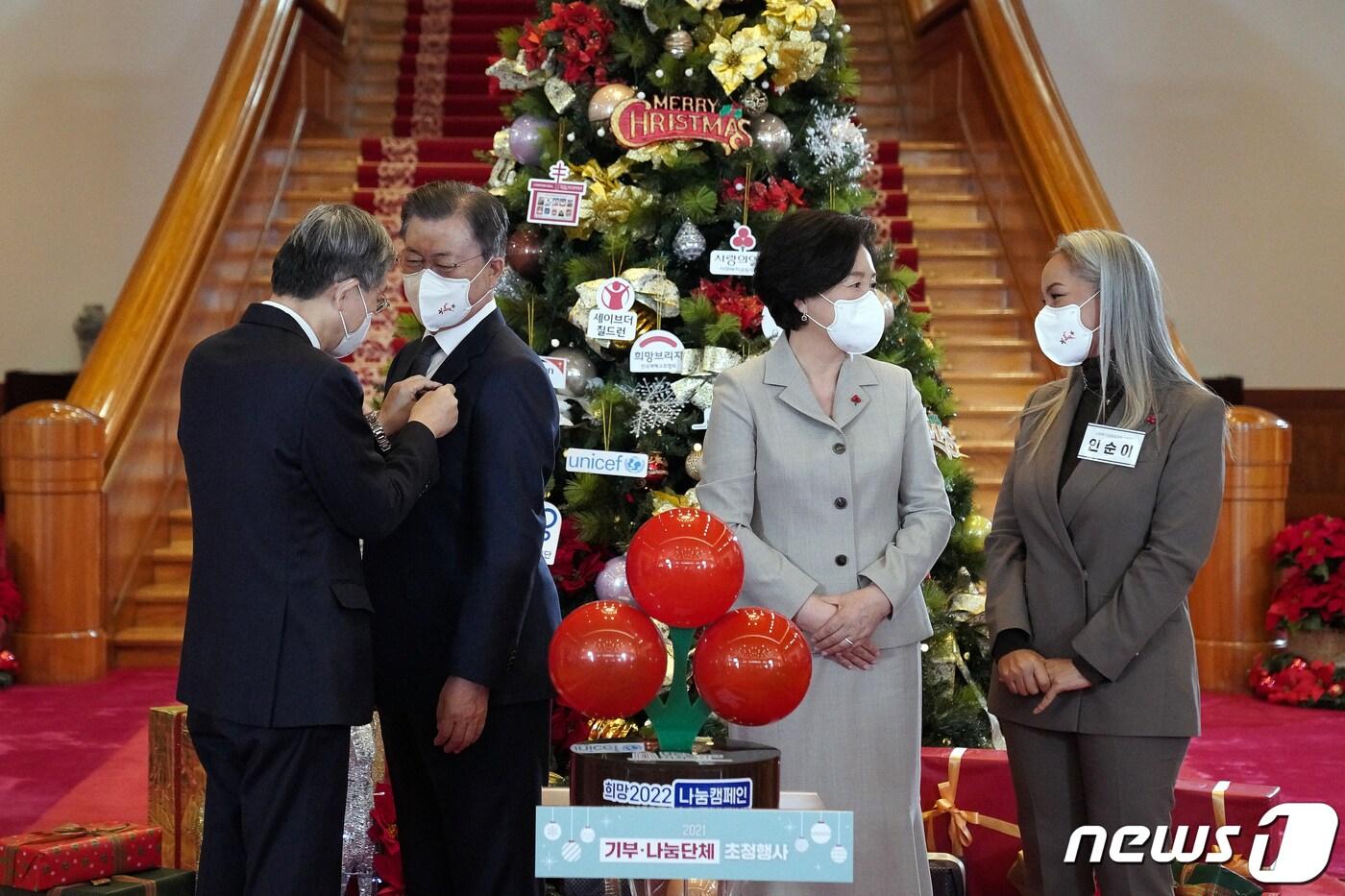 본문 이미지 - 문재인 대통령과 부인 김정숙 여사가 3일 청와대에서 열린 '2021 기부·나눔단체 초청행사'에서 사회복지공동모금회에 성금 기부에 앞서 사랑의열매 배지를 달고 있다. 2021.12.3/뉴스1 ⓒ News1 유승관 기자