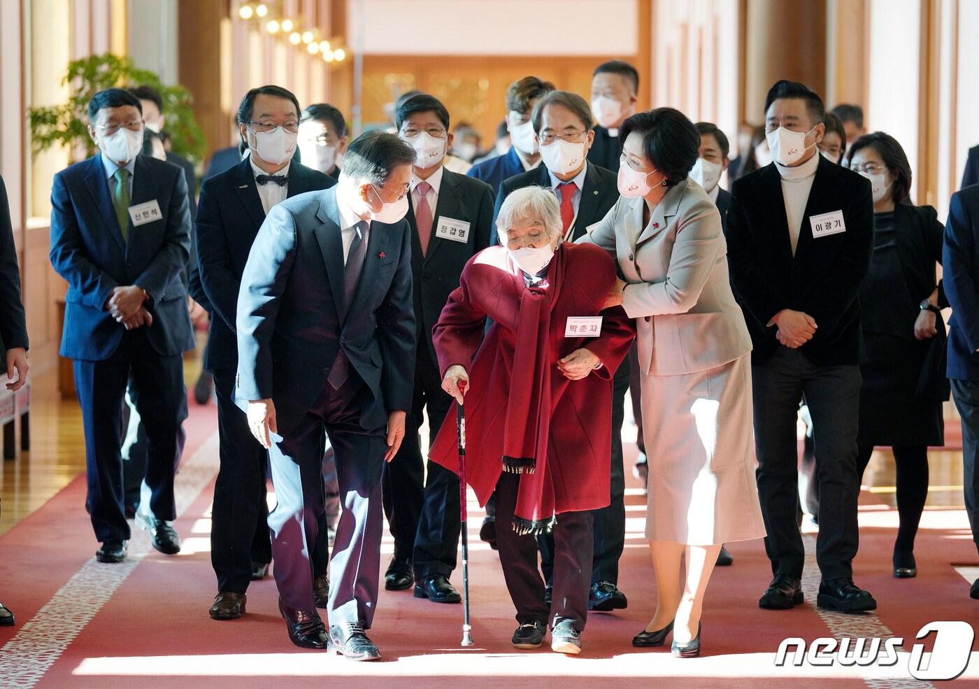 본문 이미지 - 문재인 전 대통령과 부인 김정숙 여사가 지난 2021년 12월3일 청와대에서 열린 '2021 기부·나눔단체 초청행사'에서 성금전달을 마친 후 초록우산어린이재단 기부자 박춘자 할머니와 환담장으로 이동하고 있다. 박춘자 할머니는 김밥 장사로 모은 전 재산을 기부, 40년간 장애인 봉사활동을 해온바 있다./뉴스1 ⓒ News1 유승관 기자