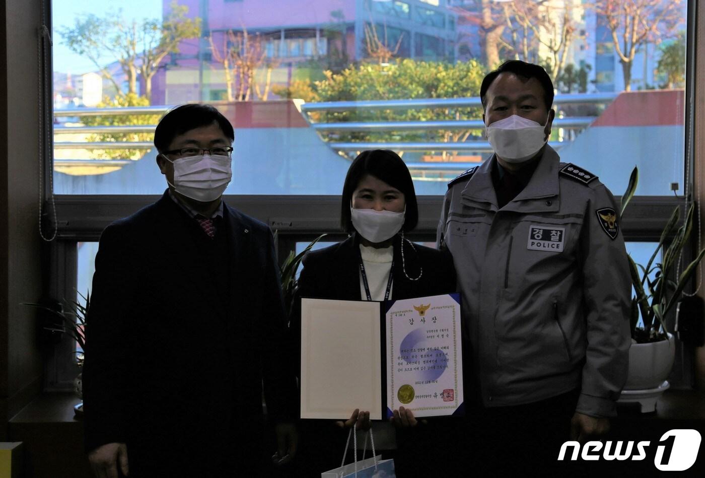 본문 이미지 - 유병조 경남 창원중부경찰서장이 30일 창원시 성산구 소재 농협은행을 찾아 80대 노인의 전화금융사기(보이스피싱) 범죄 피해를 예방한 은행원 A씨에게 감사장을 전달하고 있다. ⓒ 뉴스1