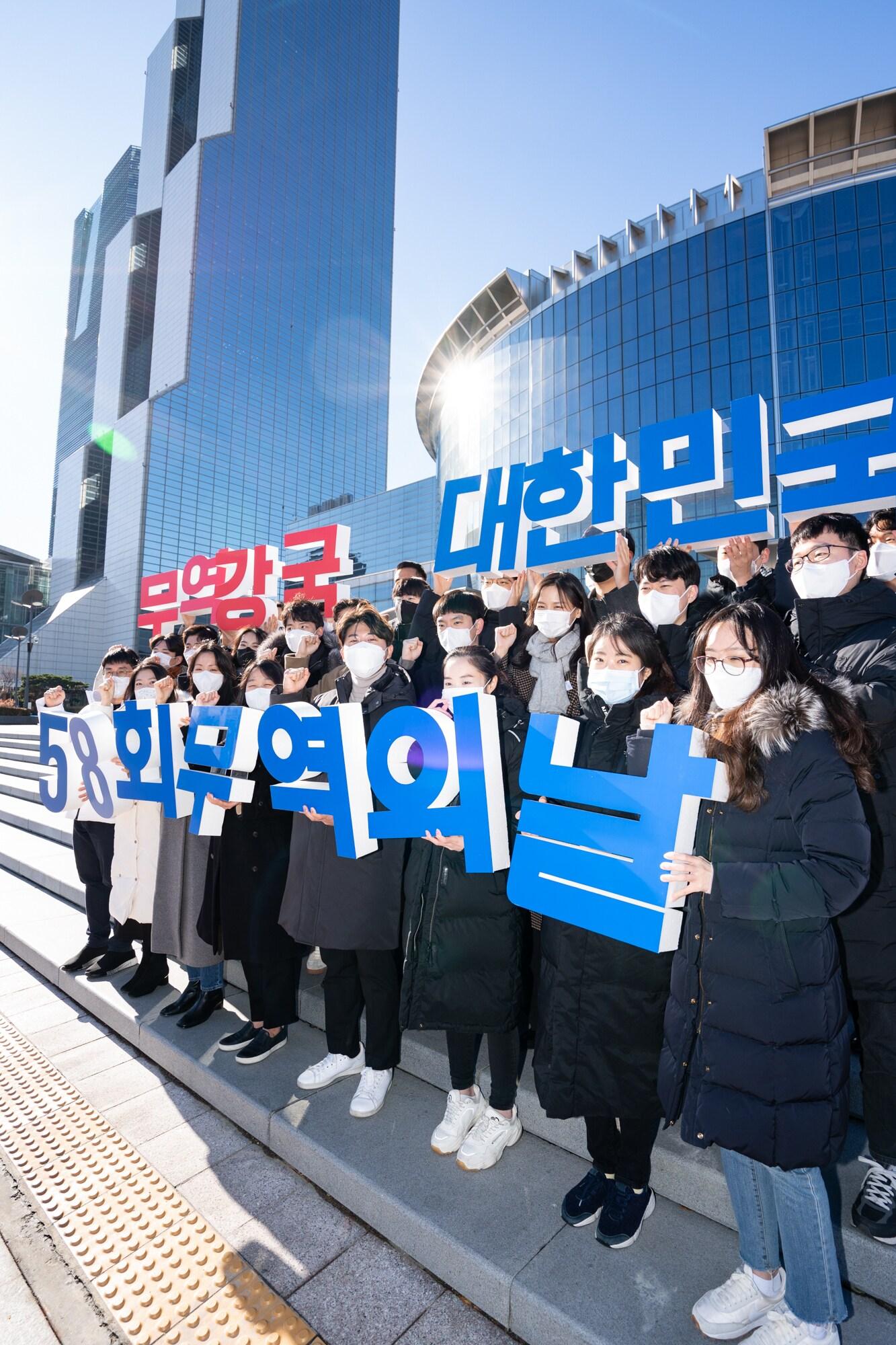본문 이미지 - '제58회 무역의 날' 기념식을 앞두고 서울 강남구 코엑스 광장에서 무역협회 임직원들이 올해 무역의 날 공식 슬로건인 ‘무역강국 대한민국’을 들고 기념촬영을 하고 있다.(한국무역협회 제공)ⓒ 뉴스1